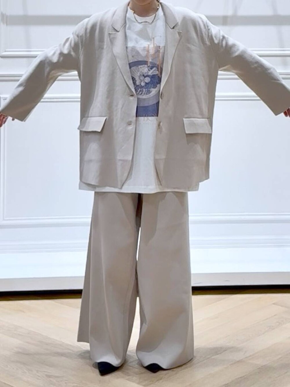 ベージュ系のパンツドレス、ブラック系のブーツ、ホワイト系のTシャツ/カットソーを着用したレディースの秋コーディネートの2枚目の写真