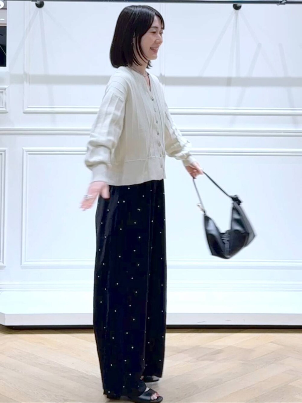 ホワイト系のカーディガン/ボレロ、ブラック系のショルダーバッグ、ブラック系のパンプスを着用したレディースの春コーディネートの3枚目の写真