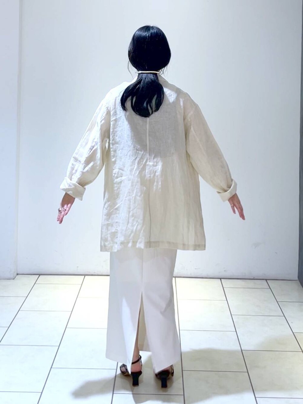 ブラック系のタンクトップ、ホワイト系のスカート、ベージュ系のテーラードジャケットを着用したレディースの夏コーディネートの4枚目の写真