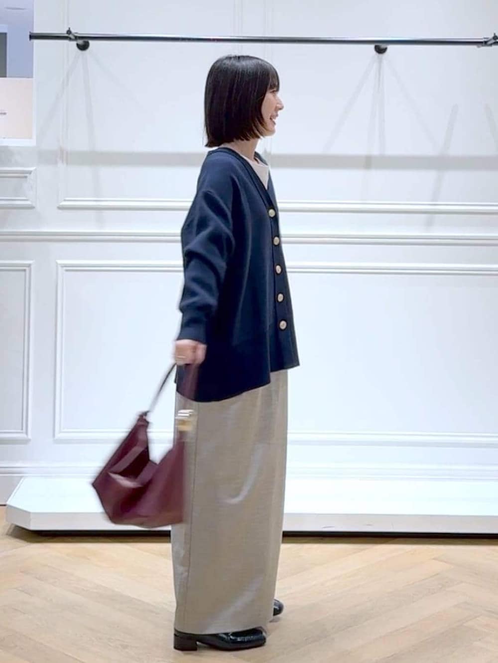 ブラック系のローファー、ブルー系のカーディガン/ボレロ、ベージュ系のショルダーバッグを着用したレディースの春コーディネートの3枚目の写真