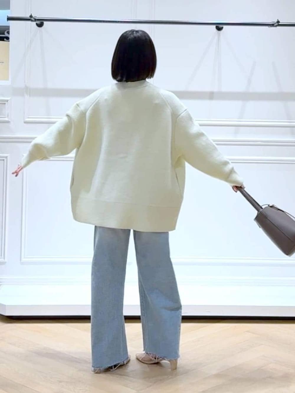 イエロー系のカーディガン/ボレロ、ブルー系のデニムパンツ、ブラウン系のショルダーバッグを着用したレディースの春コーディネートの3枚目の写真