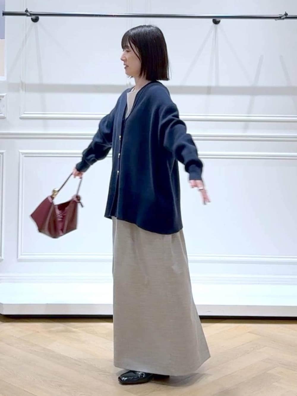 ブラック系のローファー、ブルー系のカーディガン/ボレロ、ベージュ系のショルダーバッグを着用したレディースの春コーディネートの5枚目の写真