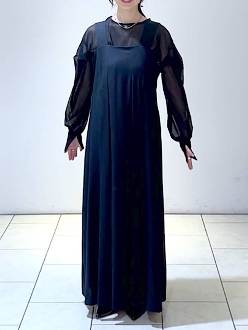 ブラック系のジャンパースカート、ブラック系のシャツ/ブラウス、ブラック系のパンプスを着用したレディースの秋コーディネートの2枚目の写真