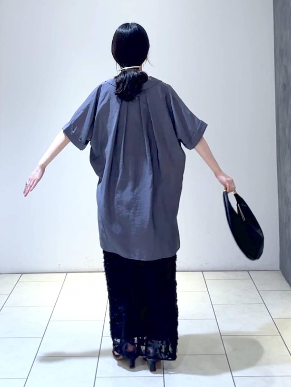 ブラック系のハンドバッグ、グレー系のシャツ/ブラウス、ブラック系のスカートを着用したレディースの夏コーディネートの4枚目の写真