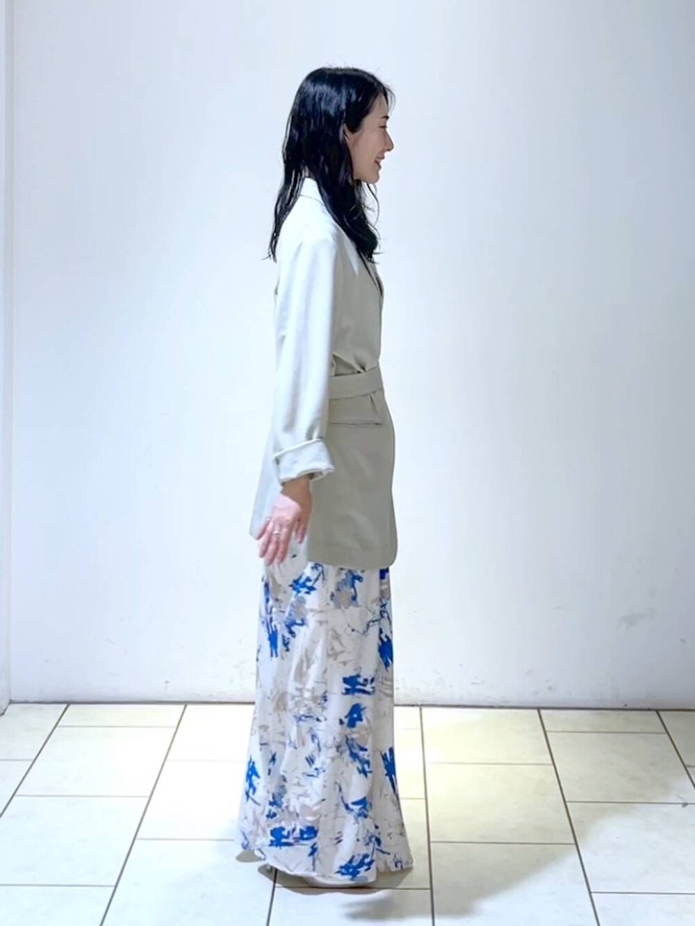 シルバー系のサンダル、ブルー系のスカート、ベージュ系のテーラードジャケットを着用したレディースの春コーディネートの3枚目の写真