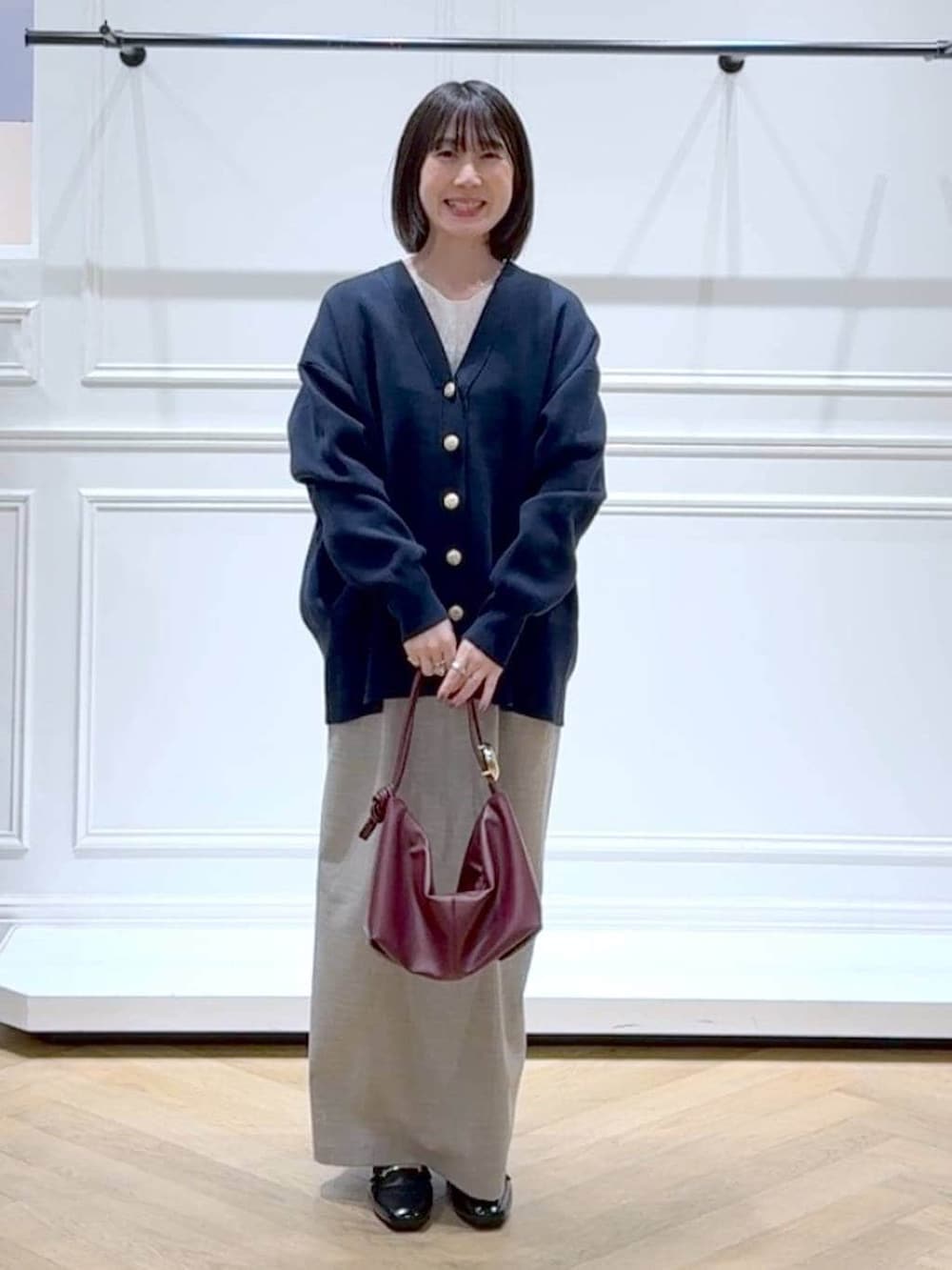 ブラック系のローファー、ブルー系のカーディガン/ボレロ、ベージュ系のショルダーバッグを着用したレディースの春コーディネートの6枚目の写真