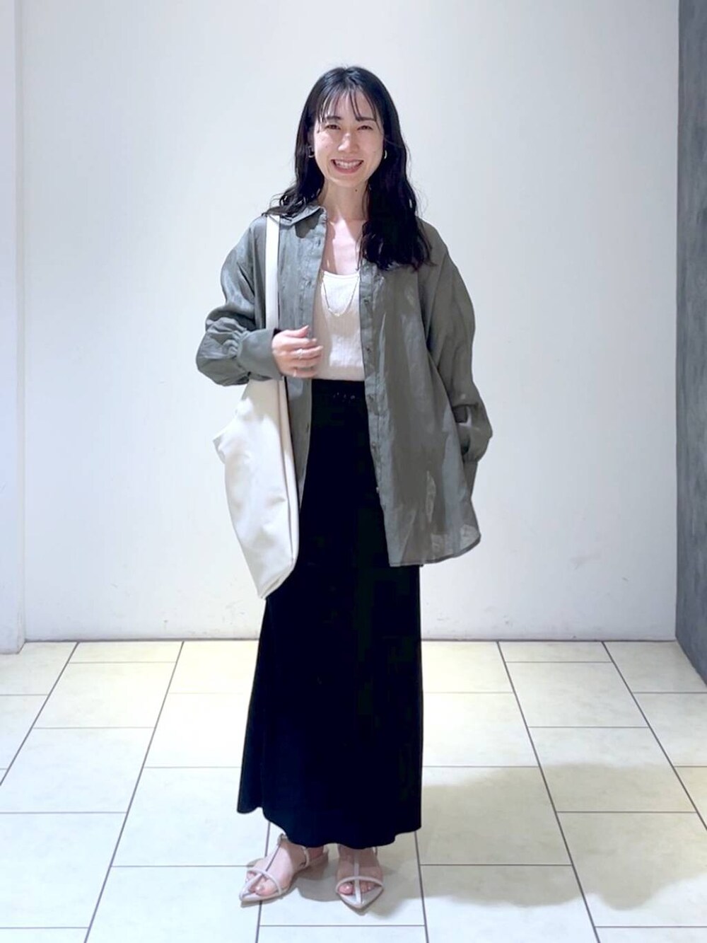 グレー系のシャツ/ブラウス、ホワイト系のトートバッグ、ホワイト系のサンダルを着用したレディースの春コーディネートの6枚目の写真