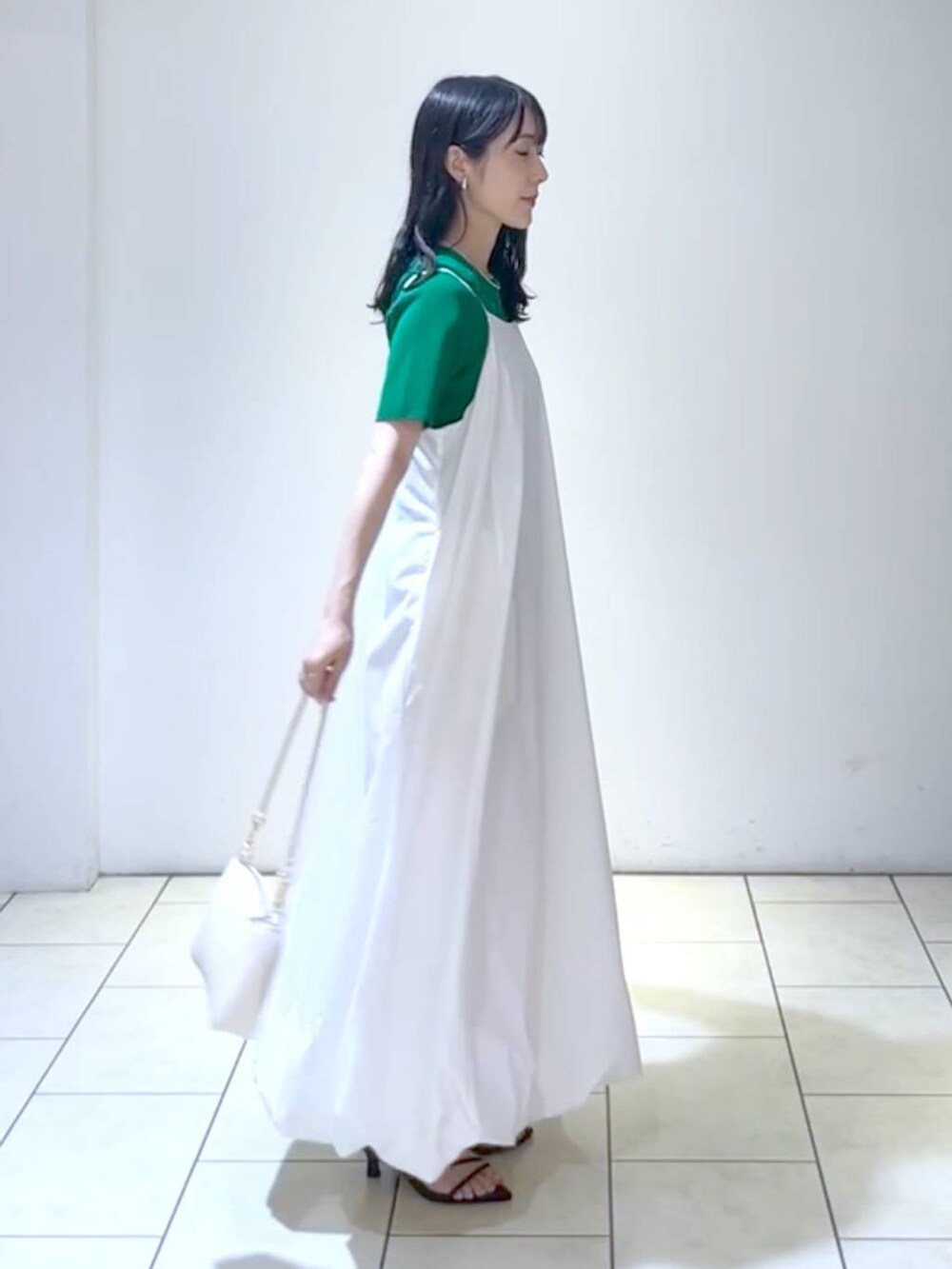 ブラック系のサンダル、グリーン系のTシャツ/カットソー、ホワイト系のショルダーバッグを着用したレディースの夏コーディネートの2枚目の写真