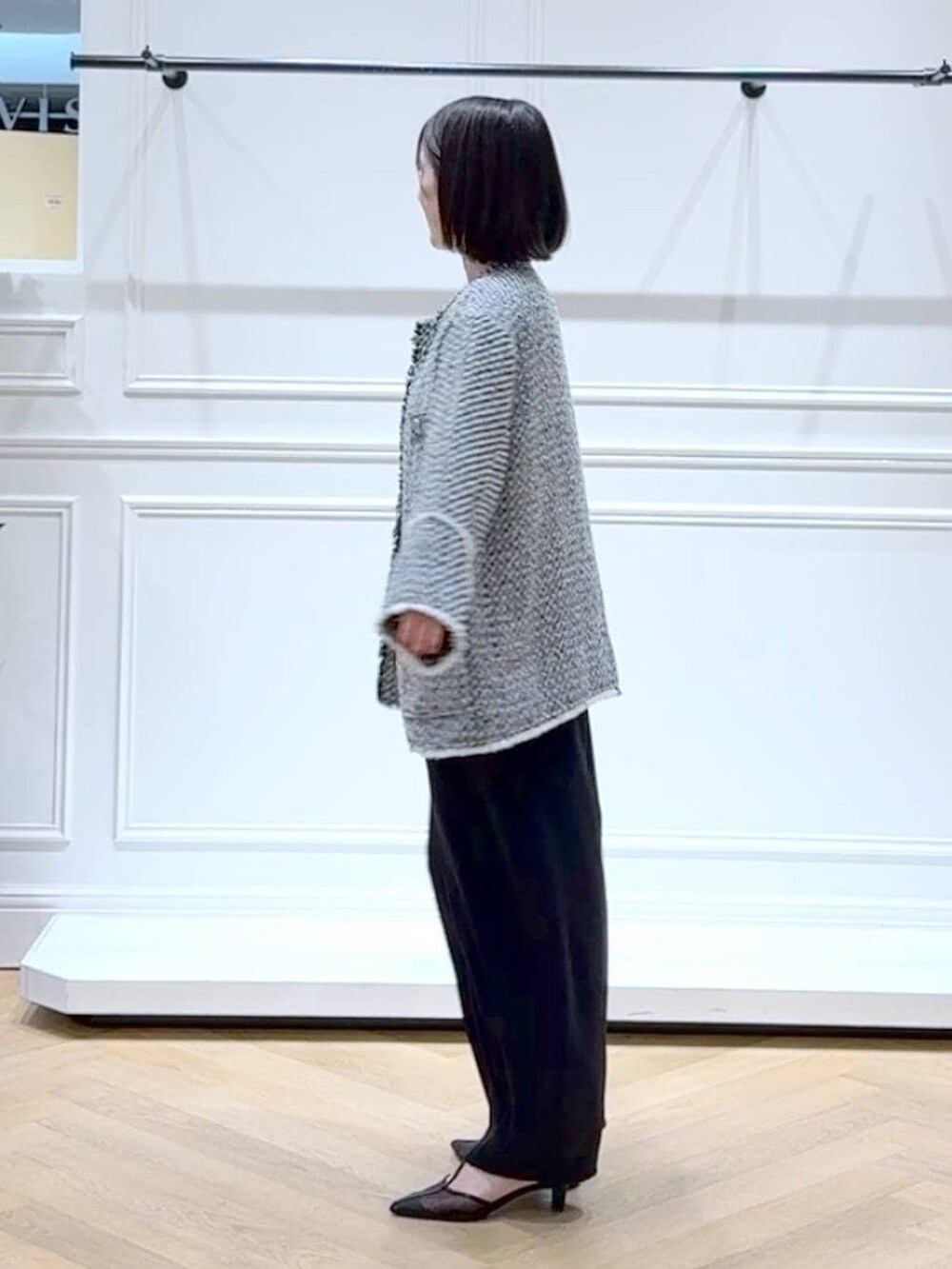 ブラック系のショルダーバッグ、ブラック系のスラックス、ブラック系のノーカラージャケットを着用したレディースの春コーディネートの5枚目の写真