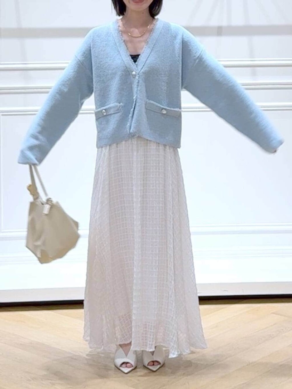 ブルー系のカーディガン/ボレロ、ホワイト系のサンダル、ホワイト系のスカートを着用したレディースの春コーディネートの2枚目の写真