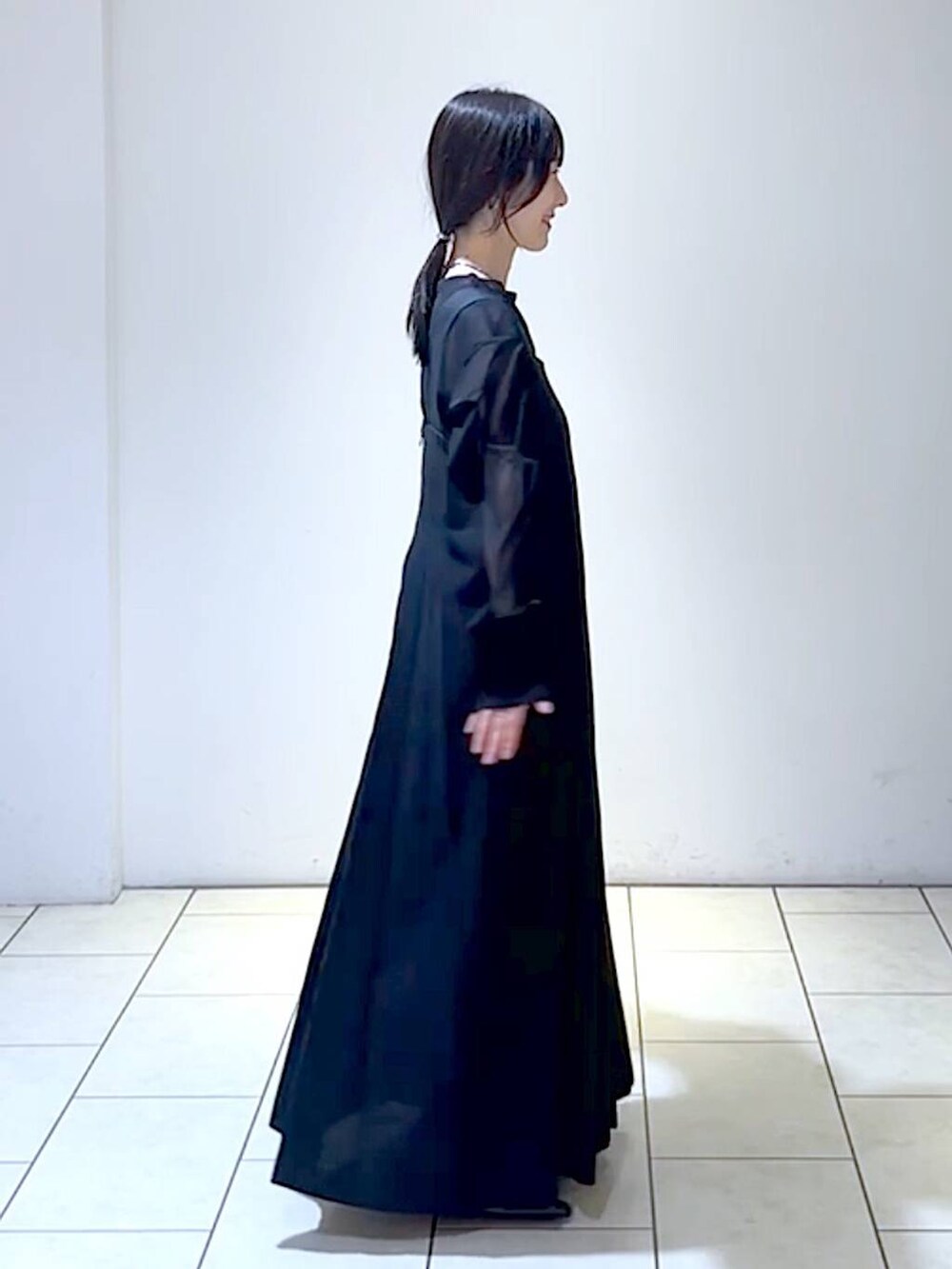 ブラック系のジャンパースカート、ブラック系のシャツ/ブラウス、ブラック系のパンプスを着用したレディースの秋コーディネートの3枚目の写真