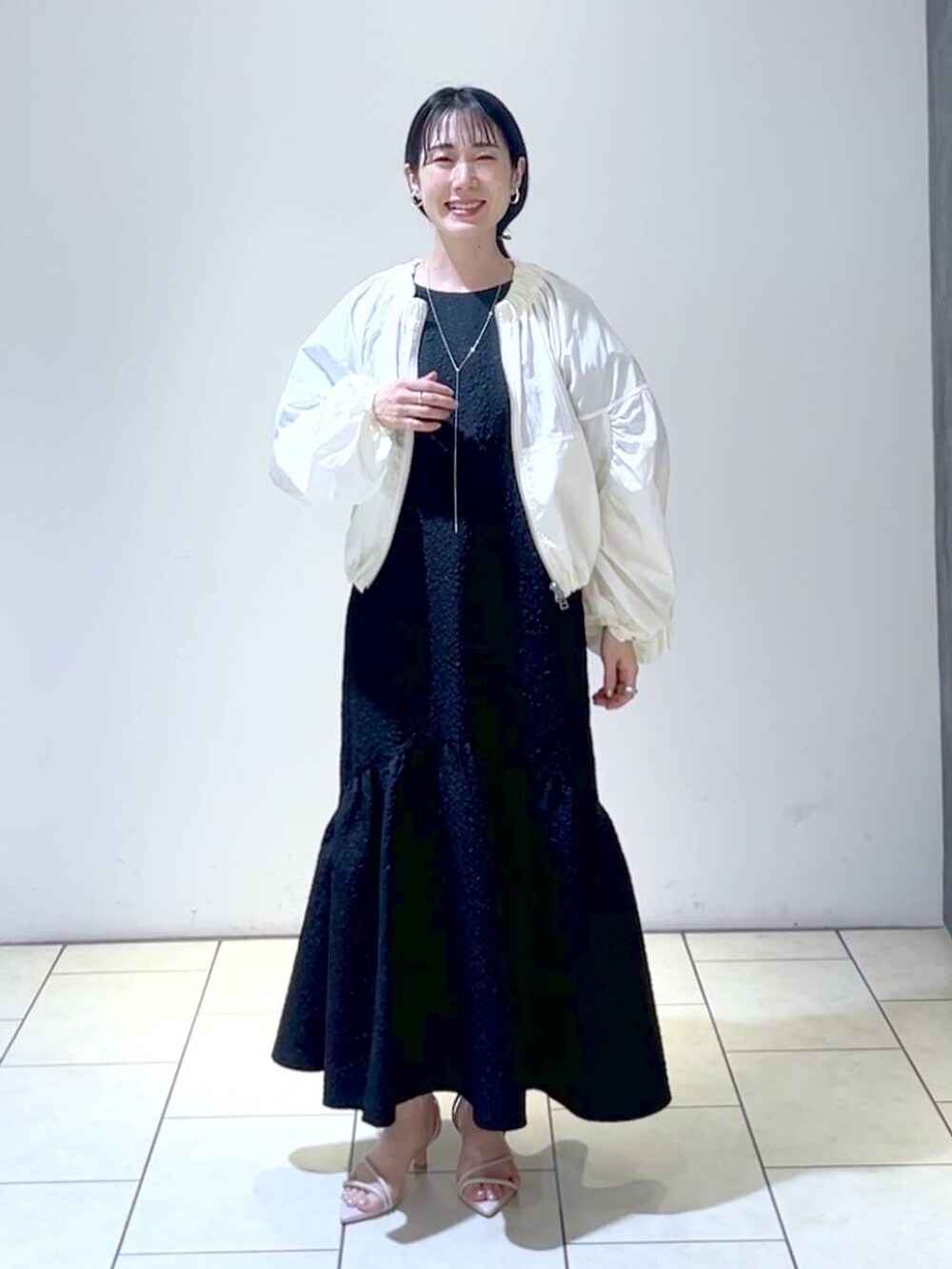 ホワイト系のブルゾン、ホワイト系のサンダル、ゴールド系のバレッタ/ヘアクリップを着用したレディースの春コーディネートの6枚目の写真