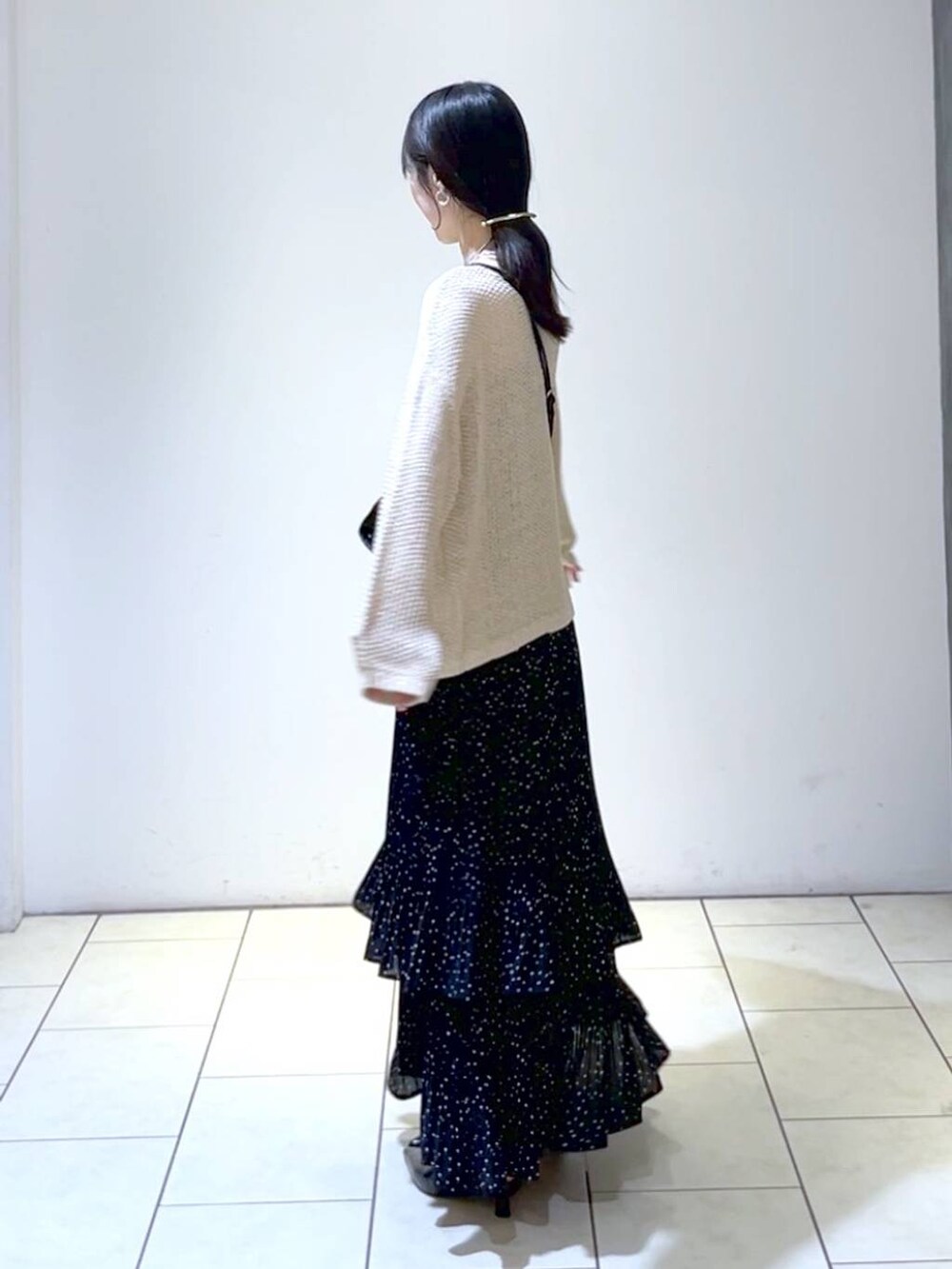 ベージュ系のニット/セーター、ブラック系のパンプス、グレー系のスカートを着用したレディースの秋コーディネートの5枚目の写真