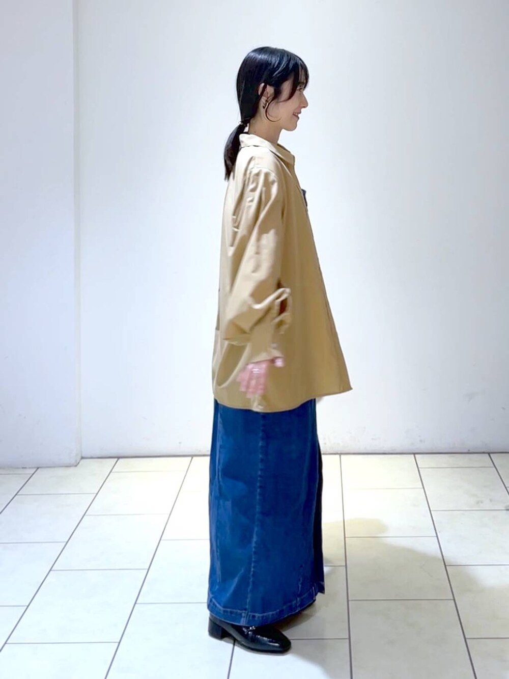 ブラウン系のシャツ/ブラウス、ブルー系のジャンパースカート、ブラック系のローファーを着用したレディースの秋コーディネートの3枚目の写真