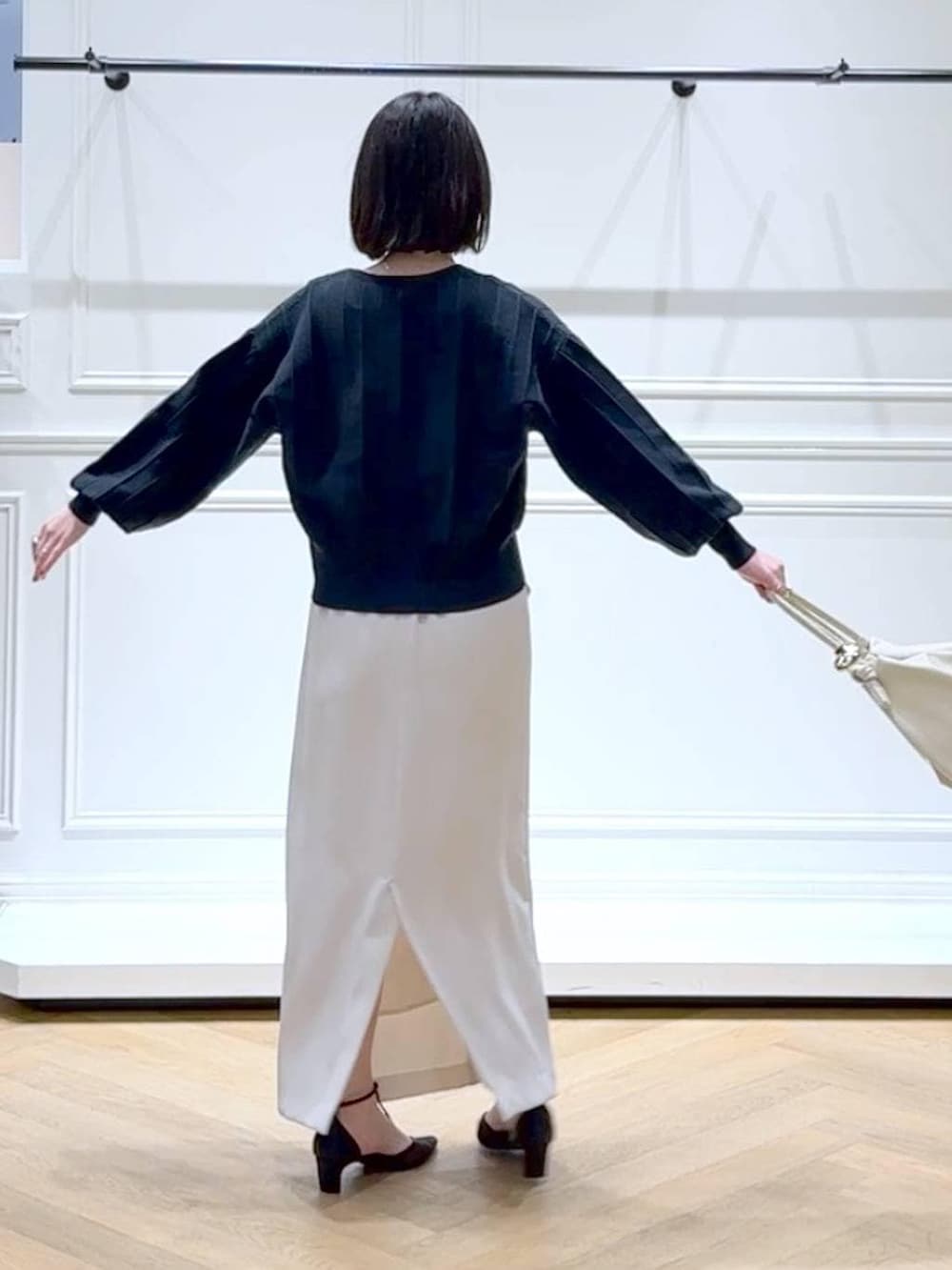 ブルー系のカーディガン/ボレロ、ブラック系のパンプス、ホワイト系のスカートを着用したレディースの春コーディネートの4枚目の写真