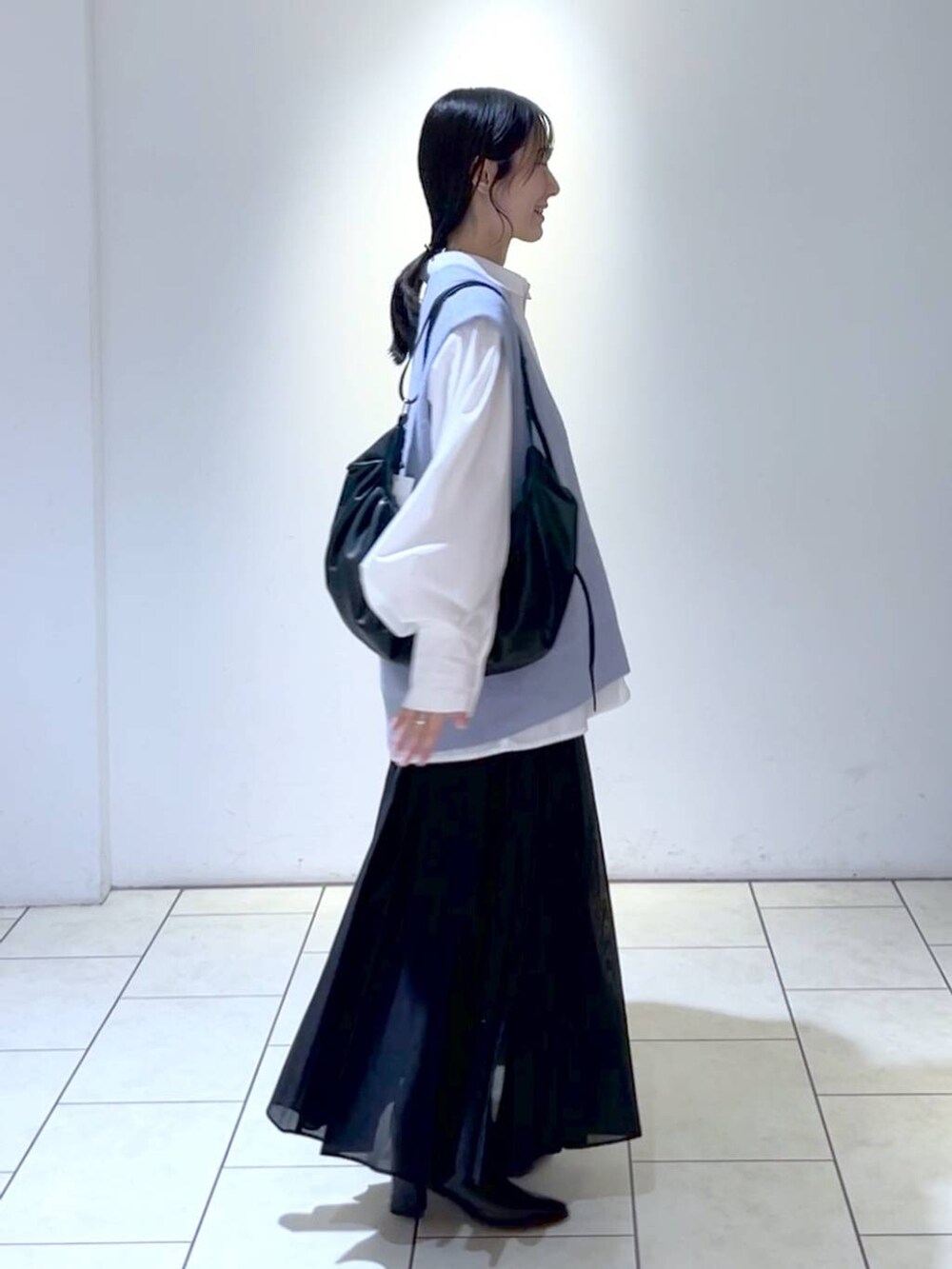 ホワイト系のシャツ/ブラウス、ブラック系のブーツ、ブラック系のスカートを着用したレディースの秋コーディネートの3枚目の写真