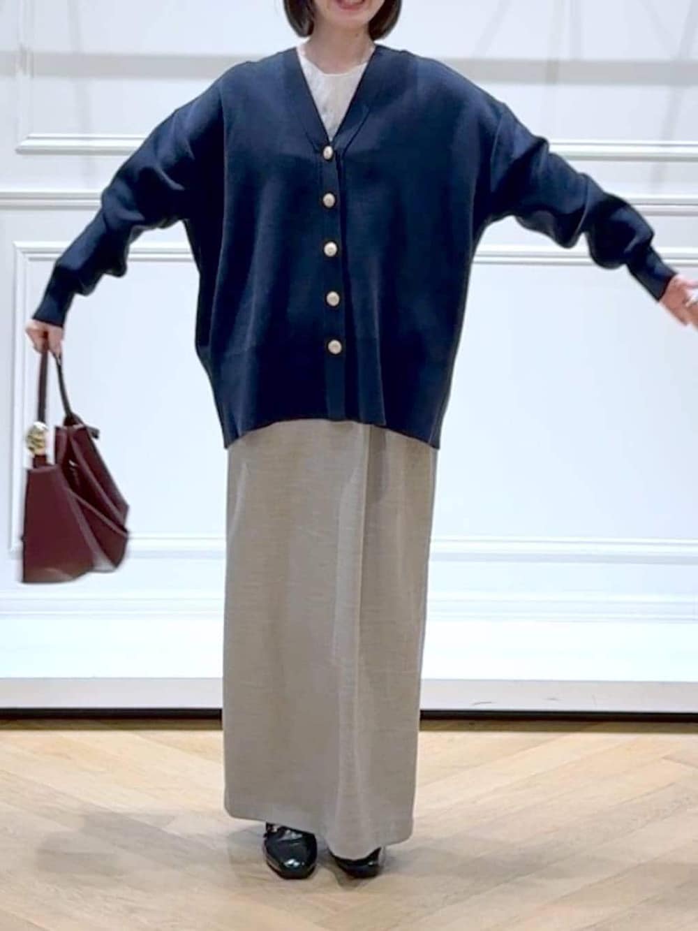 ブラック系のローファー、ブルー系のカーディガン/ボレロ、ベージュ系のショルダーバッグを着用したレディースの春コーディネートの2枚目の写真