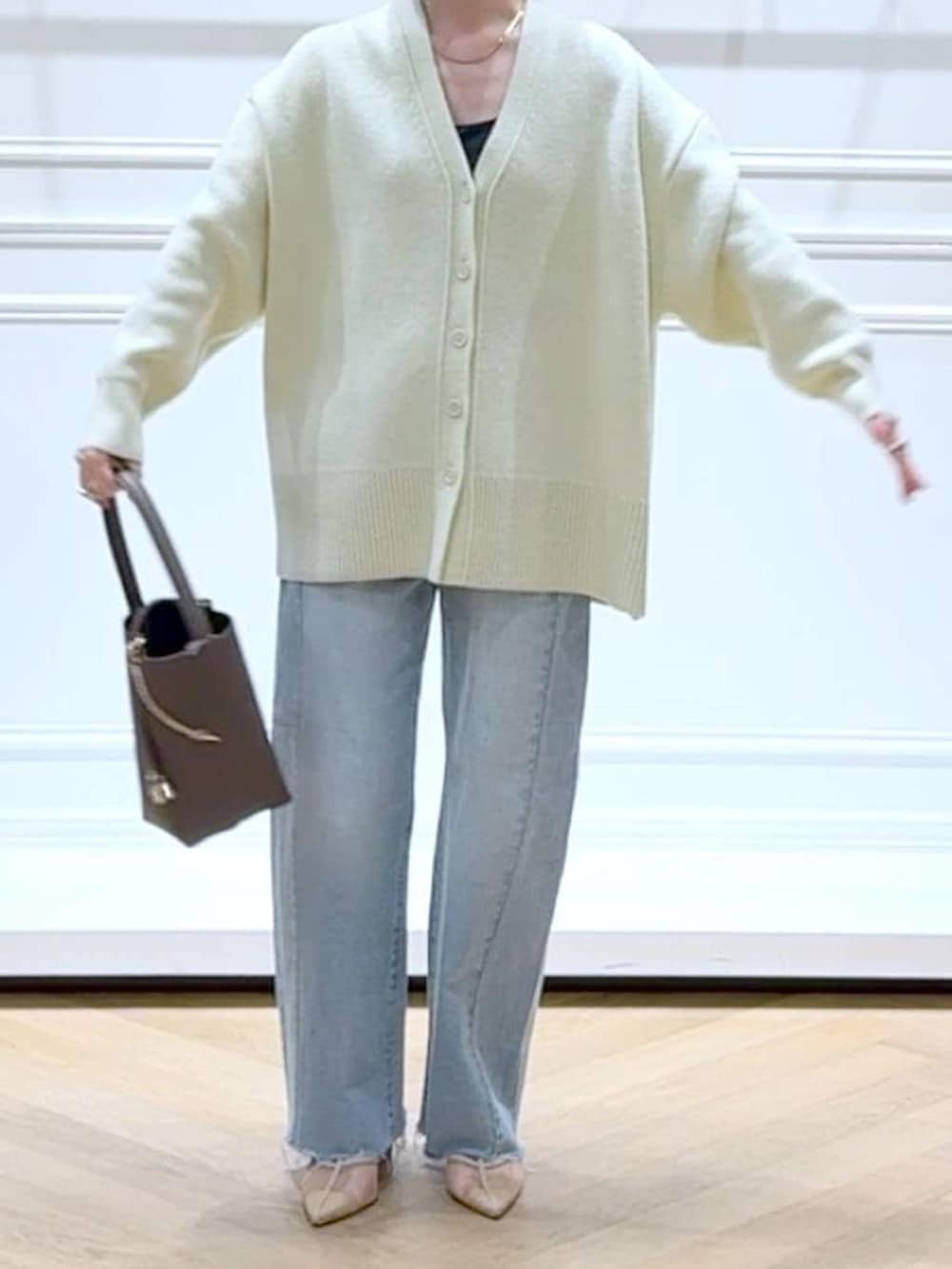 イエロー系のカーディガン/ボレロ、ブルー系のデニムパンツ、ブラウン系のショルダーバッグを着用したレディースの春コーディネートの5枚目の写真