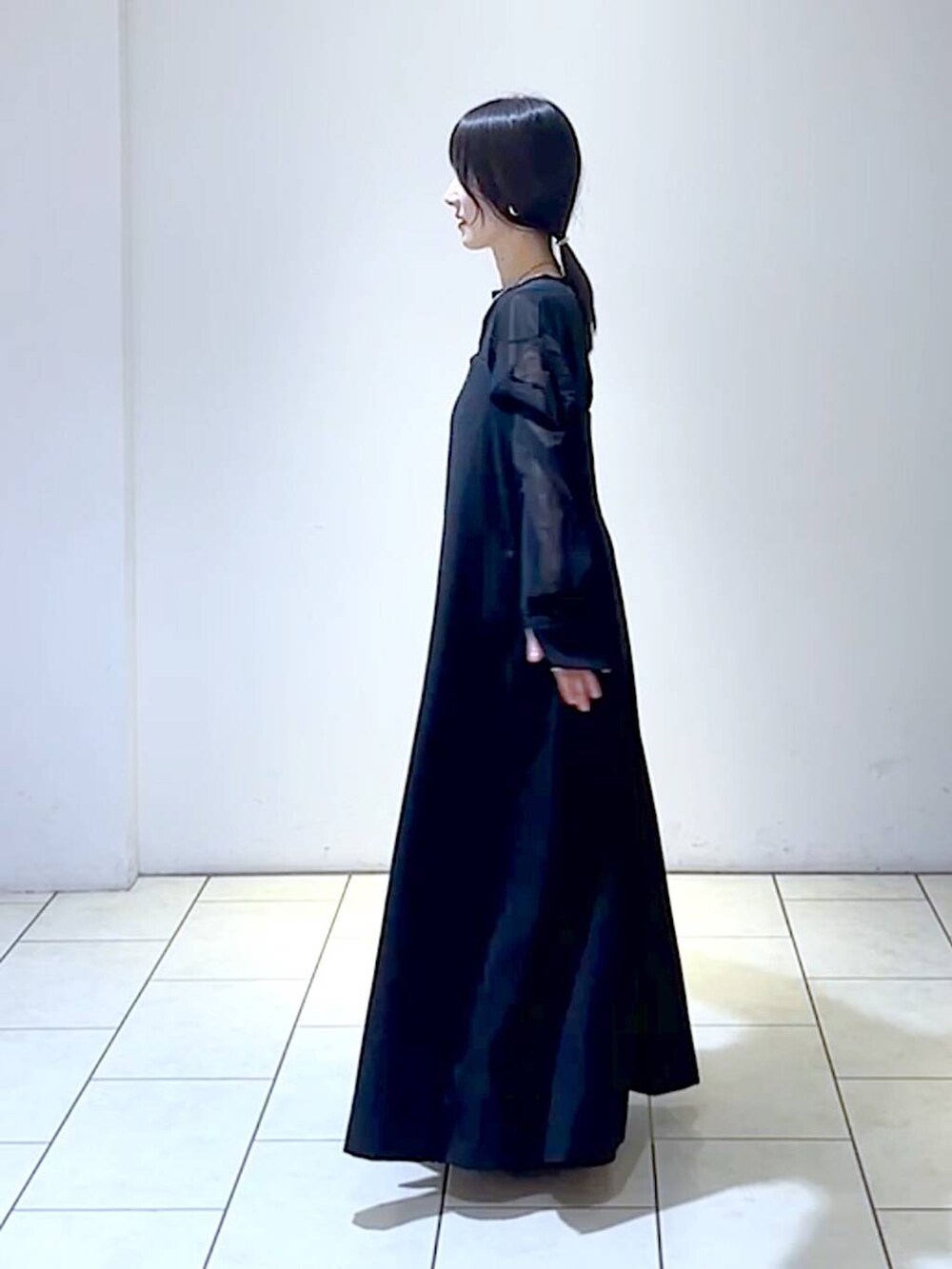 ブラック系のジャンパースカート、ブラック系のシャツ/ブラウス、ブラック系のパンプスを着用したレディースの秋コーディネートの5枚目の写真