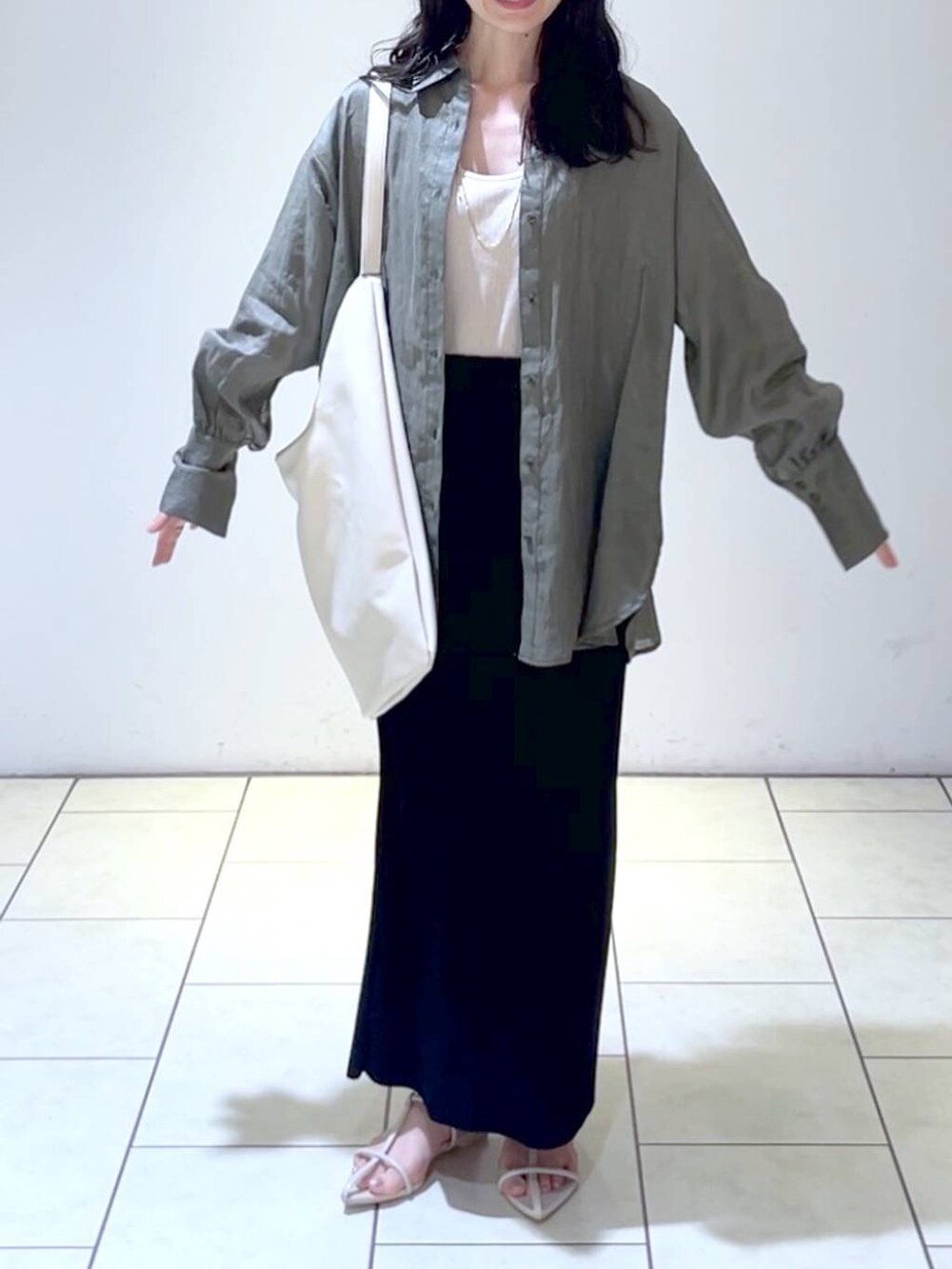 グレー系のシャツ/ブラウス、ホワイト系のトートバッグ、ホワイト系のサンダルを着用したレディースの春コーディネートの2枚目の写真