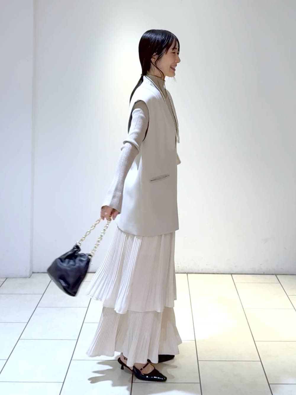ホワイト系のスカート、ベージュ系のスーツセット、ホワイト系のニット/セーターを着用したレディースの冬コーディネートの3枚目の写真