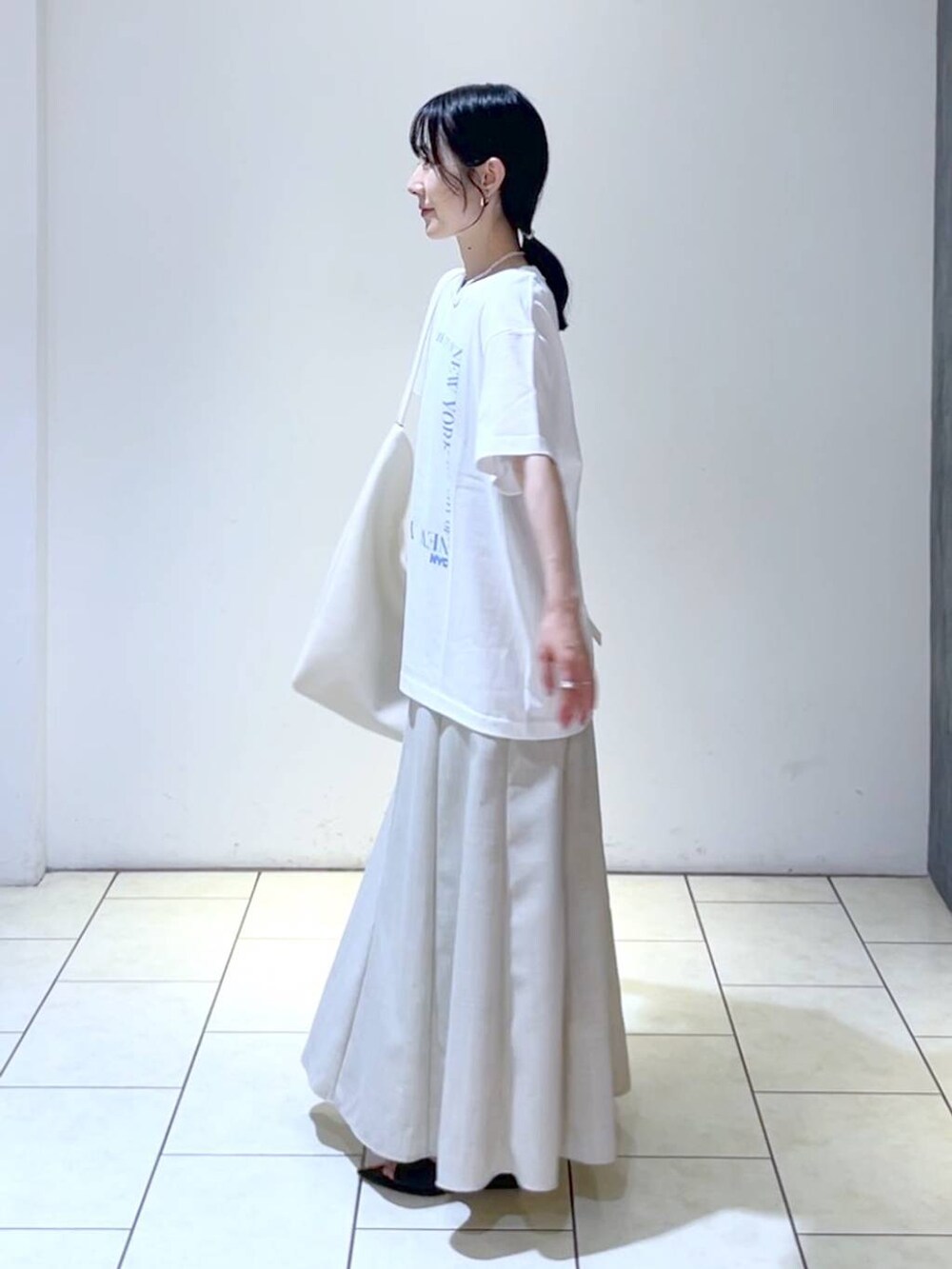 ブラック系のサンダル、ホワイト系のトートバッグ、ベージュ系のスカートを着用したレディースの夏コーディネートの5枚目の写真