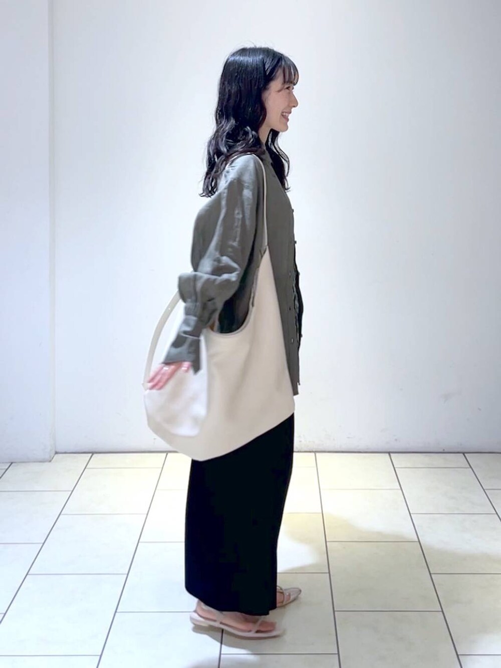 グレー系のシャツ/ブラウス、ホワイト系のトートバッグ、ホワイト系のサンダルを着用したレディースの春コーディネートの3枚目の写真