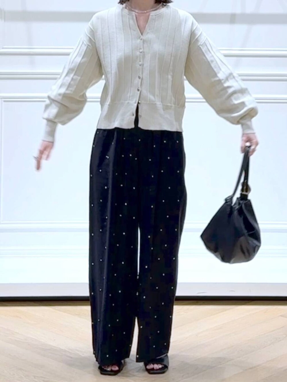 ホワイト系のカーディガン/ボレロ、ブラック系のショルダーバッグ、ブラック系のパンプスを着用したレディースの春コーディネートの2枚目の写真