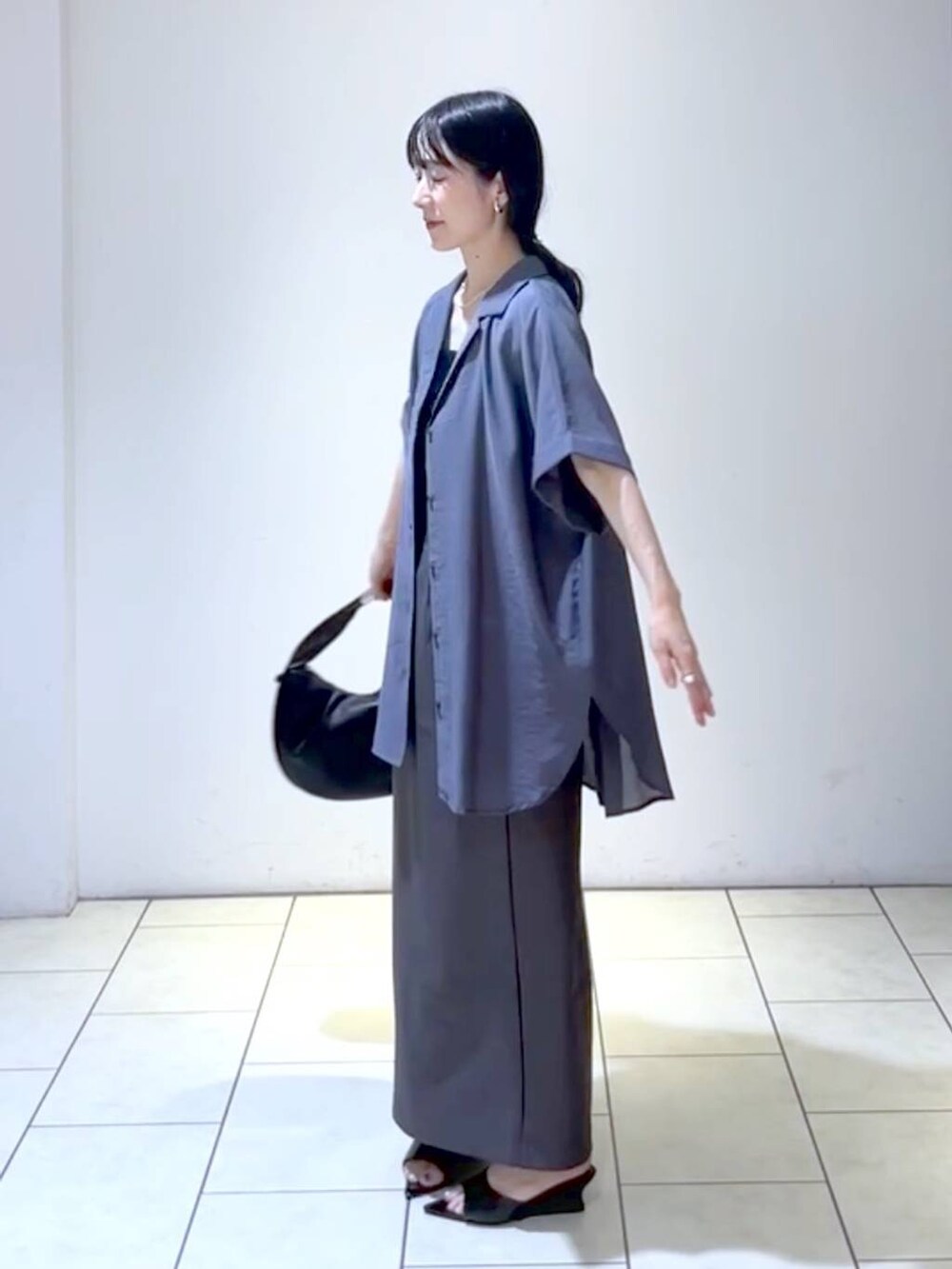 ブラック系のサンダル、ブラック系のハンドバッグ、ブラック系のタンクトップを着用したレディースの夏コーディネートの5枚目の写真