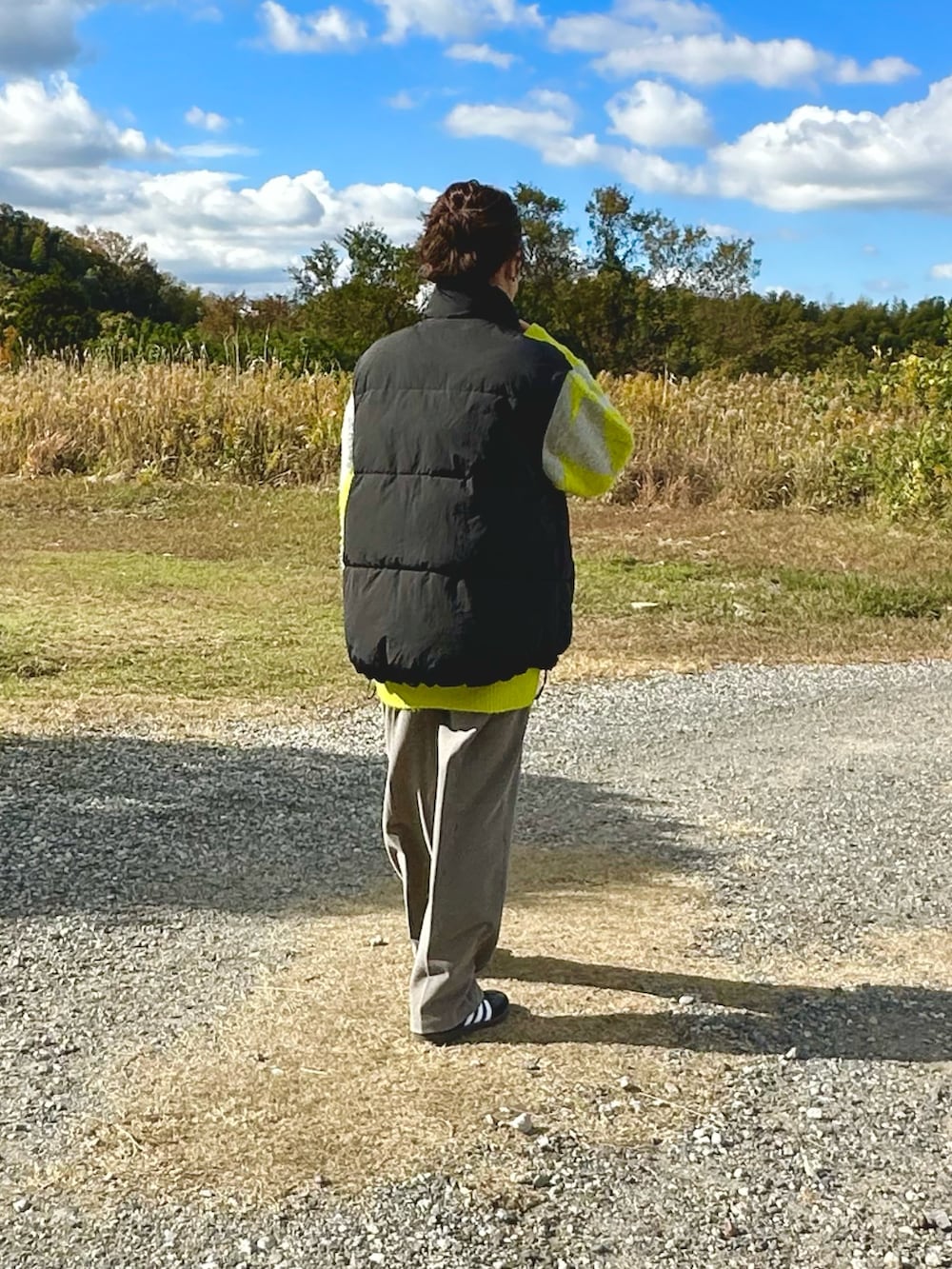 グレー系のニット/セーター、グレー系のスラックス、ブラック系のスニーカーを着用したレディースの冬コーディネートの2枚目の写真