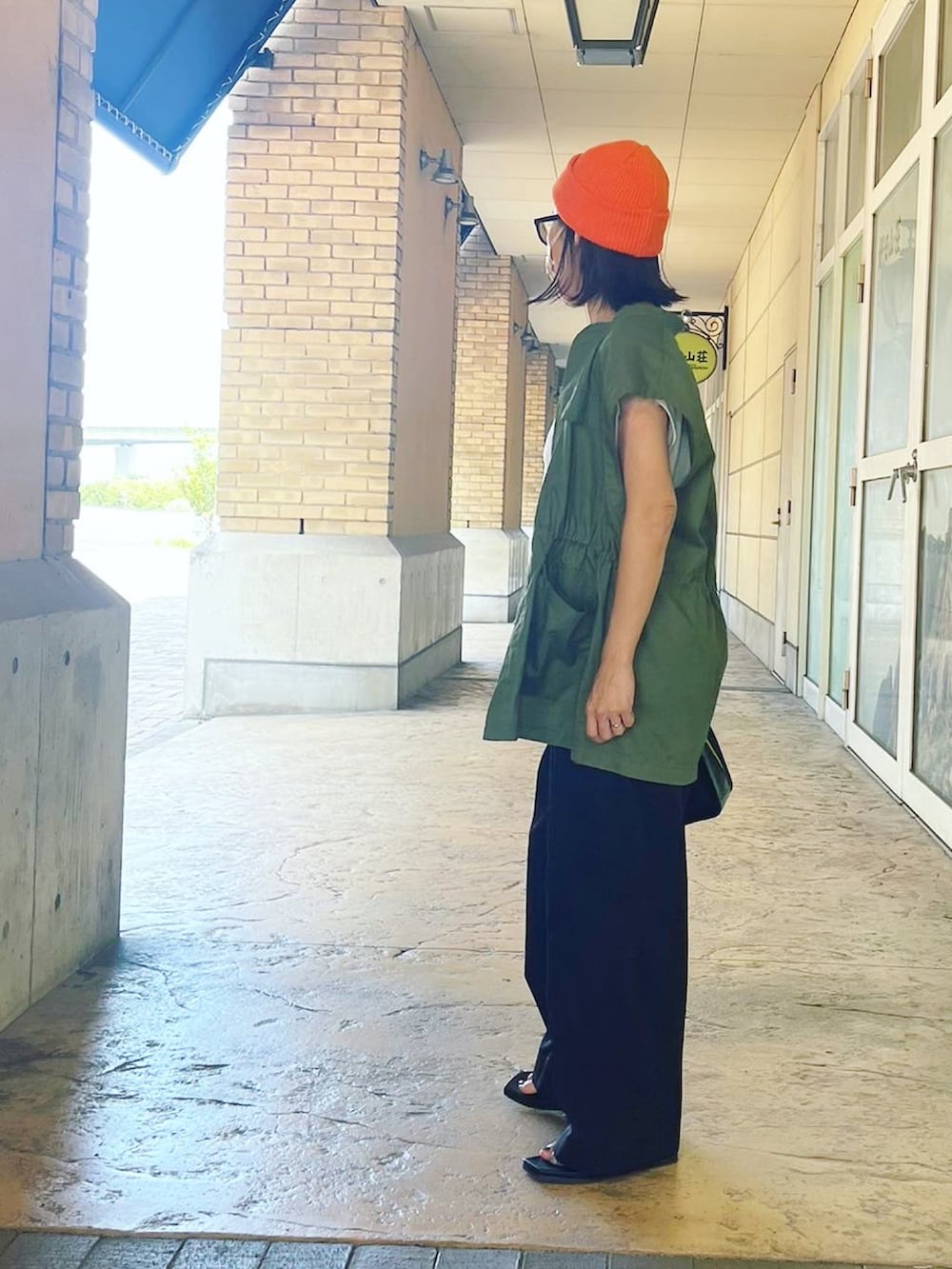 ホワイト系のTシャツ/カットソー、グリーン系のベスト、ブラック系のバッグを着用したレディースの夏コーディネートの3枚目の写真