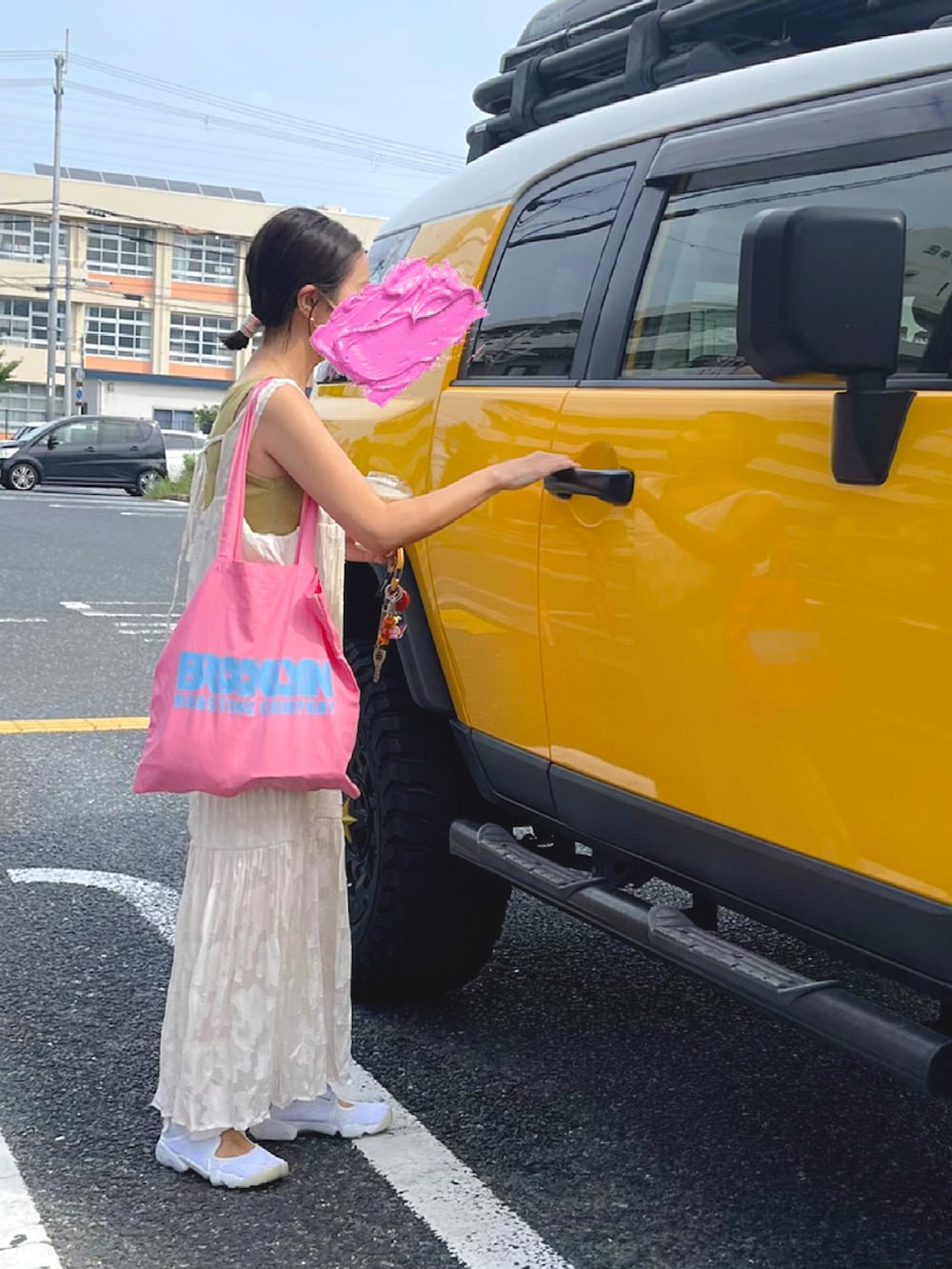 ホワイト系のワンピース、ピンク系のトートバッグ、ホワイト系のスニーカーを着用したレディースの夏コーディネートの2枚目の写真