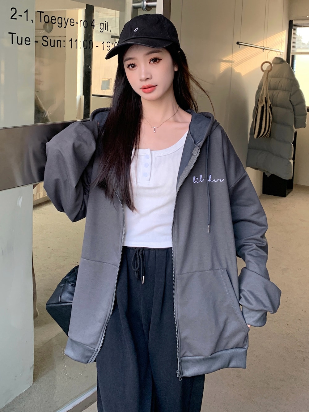 グレー系のパーカーを着用したレディースの冬コーディネートの3枚目の写真