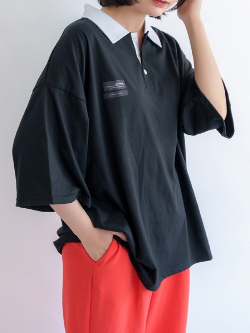 ブラック系のポロシャツを着用したレディースの夏コーディネートの2枚目の写真