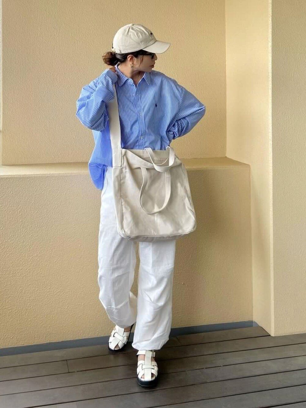 ベージュ系のショルダーバッグを着用したレディースの夏コーディネートの2枚目の写真