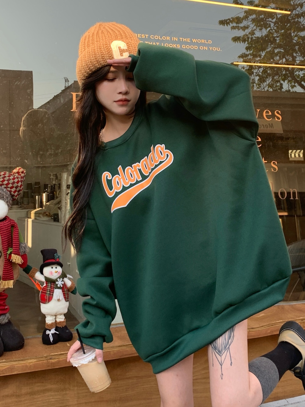 グリーン系のスウェットを着用したレディースの冬コーディネートの2枚目の写真