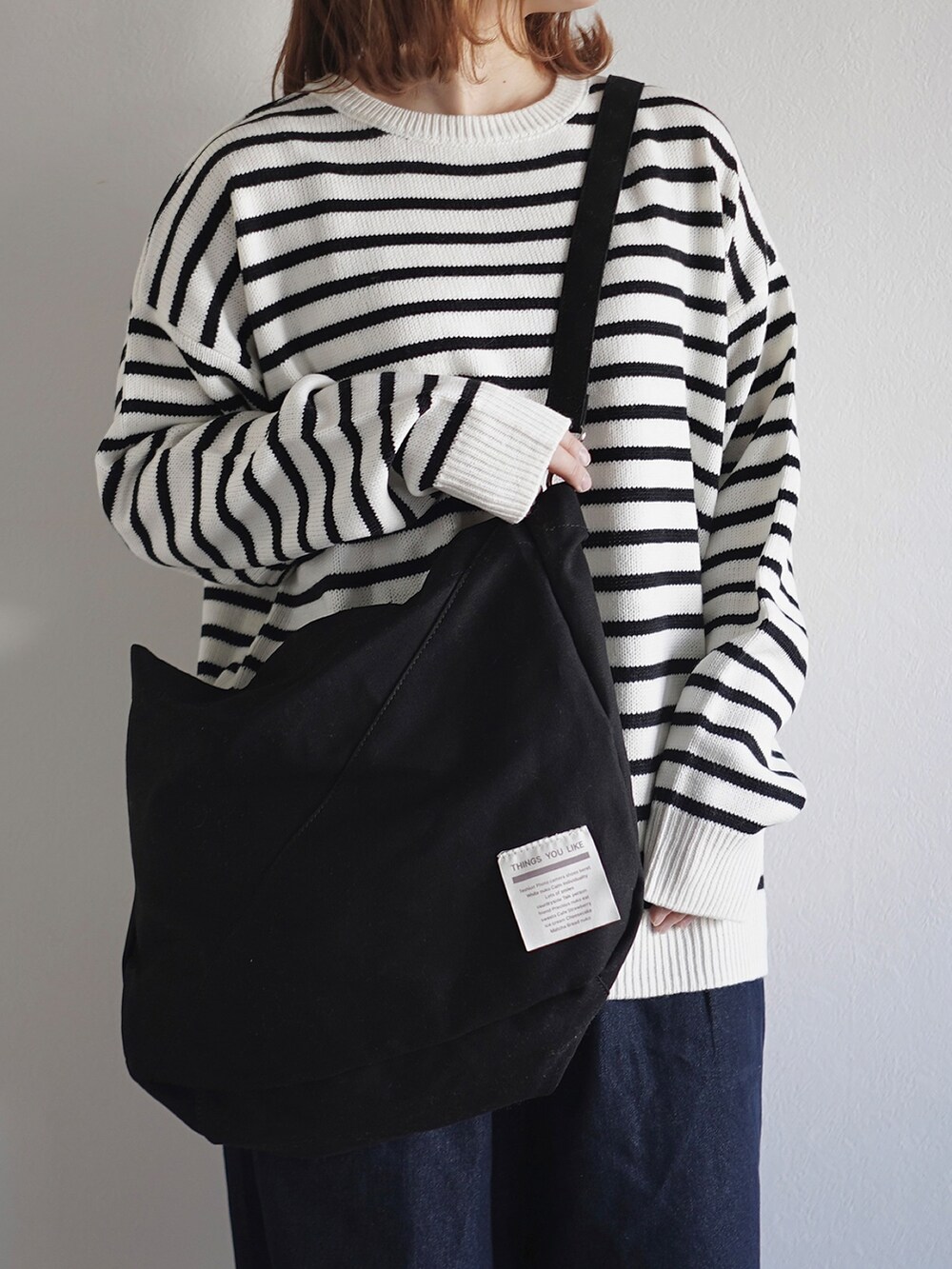 ベージュ系のトートバッグを着用したレディースの冬コーディネートの2枚目の写真