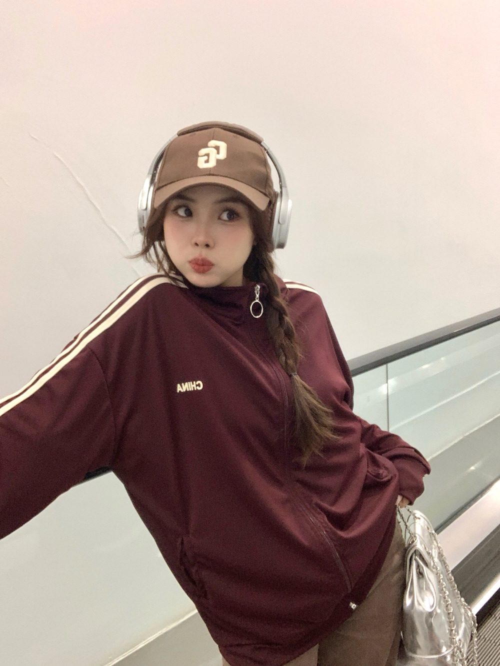 レッド系のジャージを着用したレディースの秋コーディネートの2枚目の写真