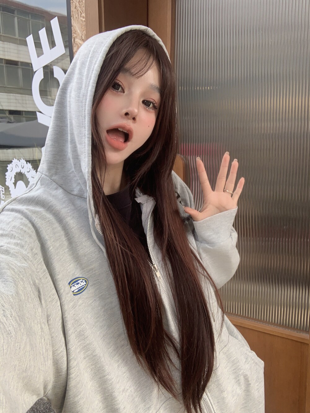 グレー系のパーカーを着用したレディースの冬コーディネートの2枚目の写真