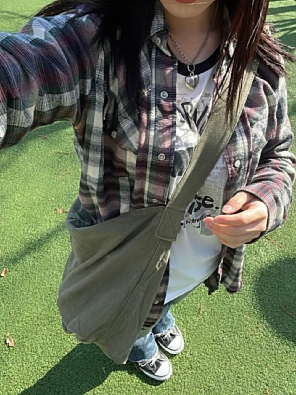 グリーン系のショルダーバッグを着用したレディースの春コーディネートの3枚目の写真