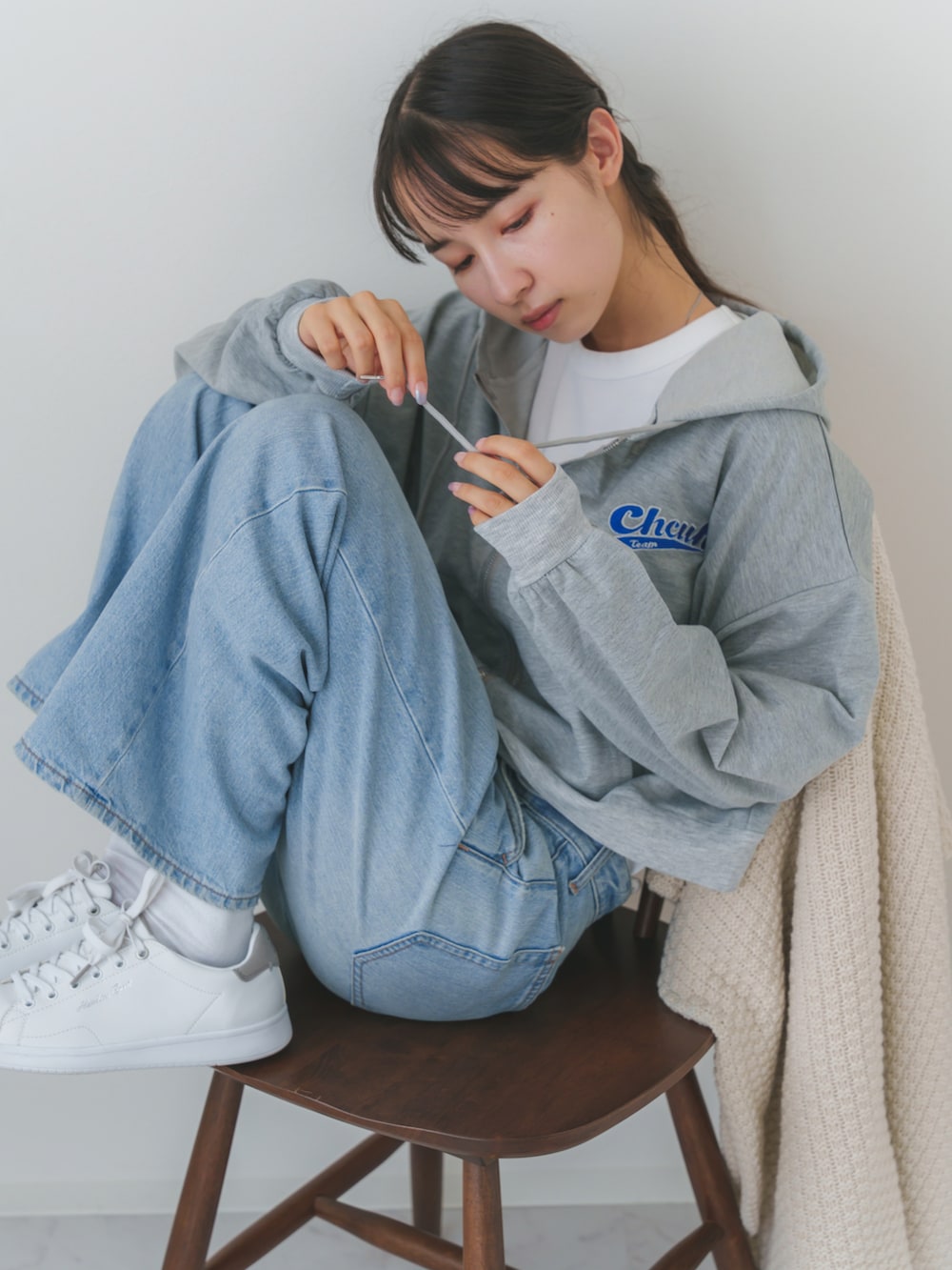 グレー系のパーカーを着用したレディースの秋コーディネートの3枚目の写真