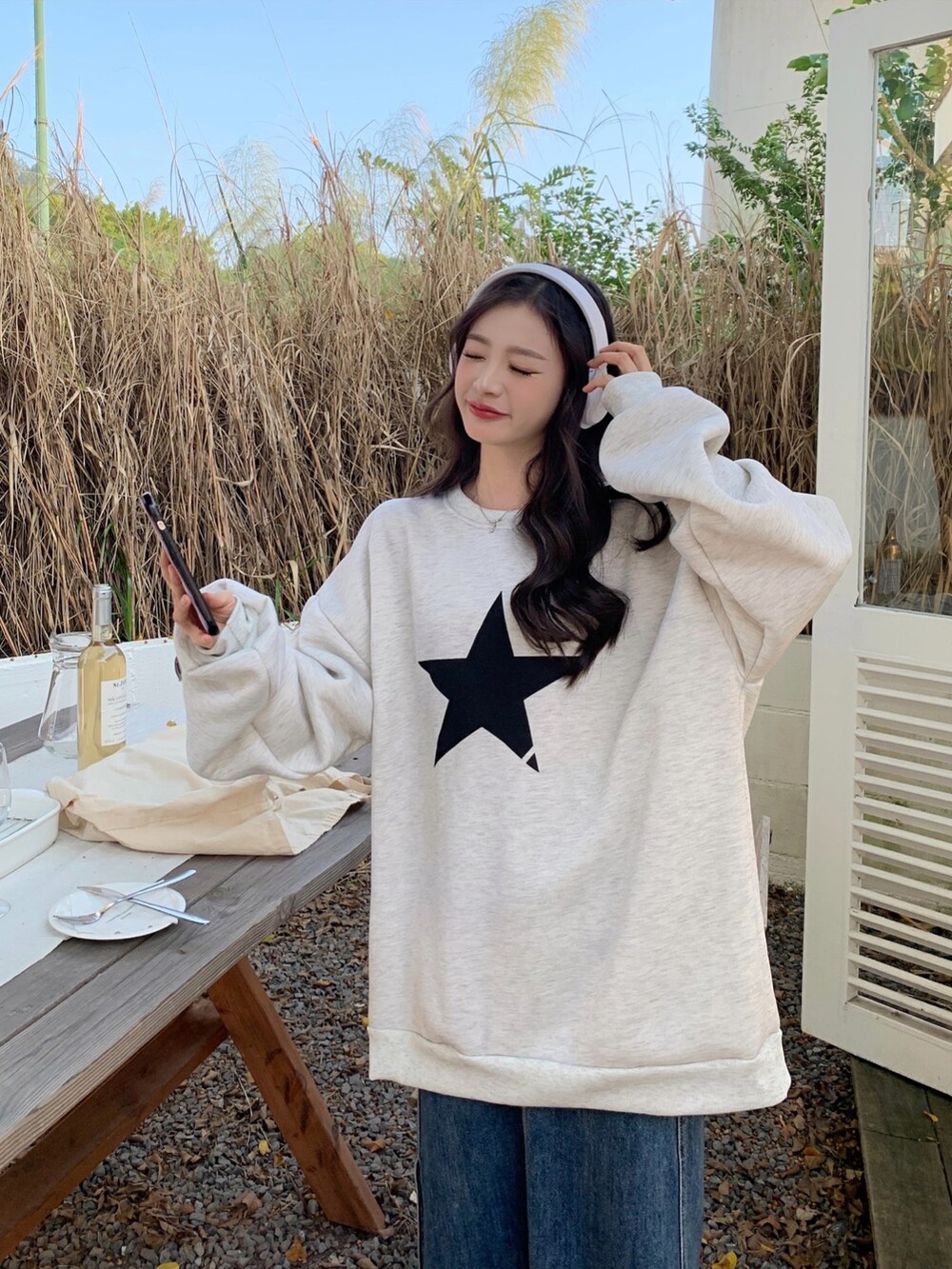 グレー系のスウェットを着用したレディースの秋コーディネートの3枚目の写真