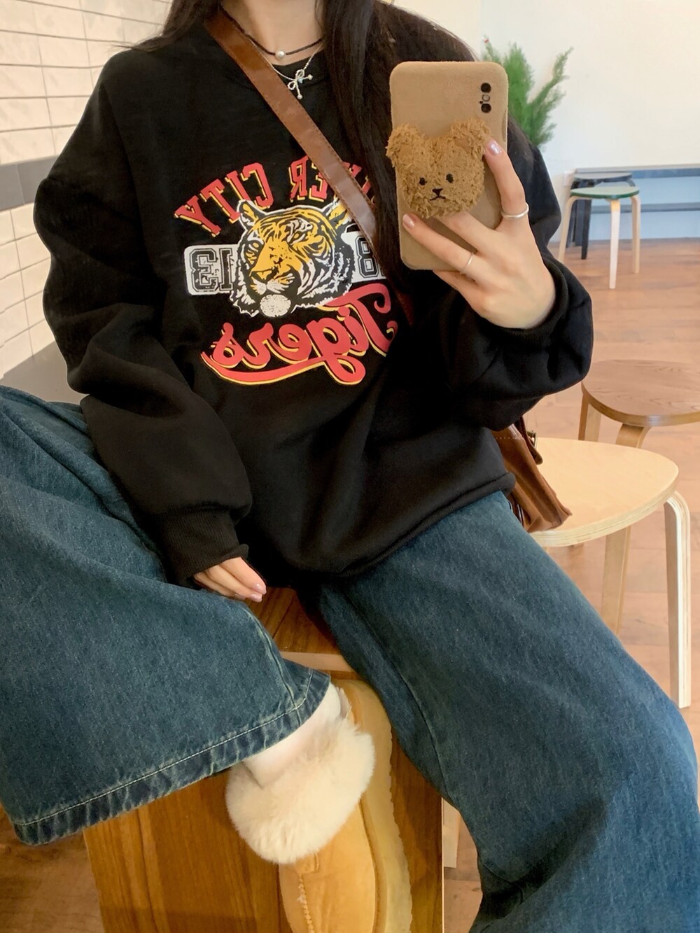 ブラック系のスウェットを着用したレディースの冬コーディネートの4枚目の写真