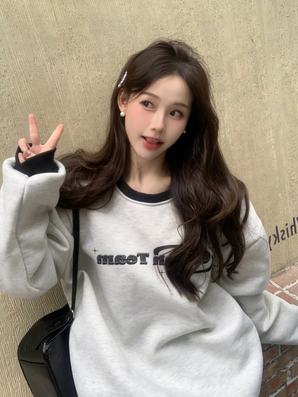 グレー系のスウェットを着用したレディースの秋コーディネートの3枚目の写真