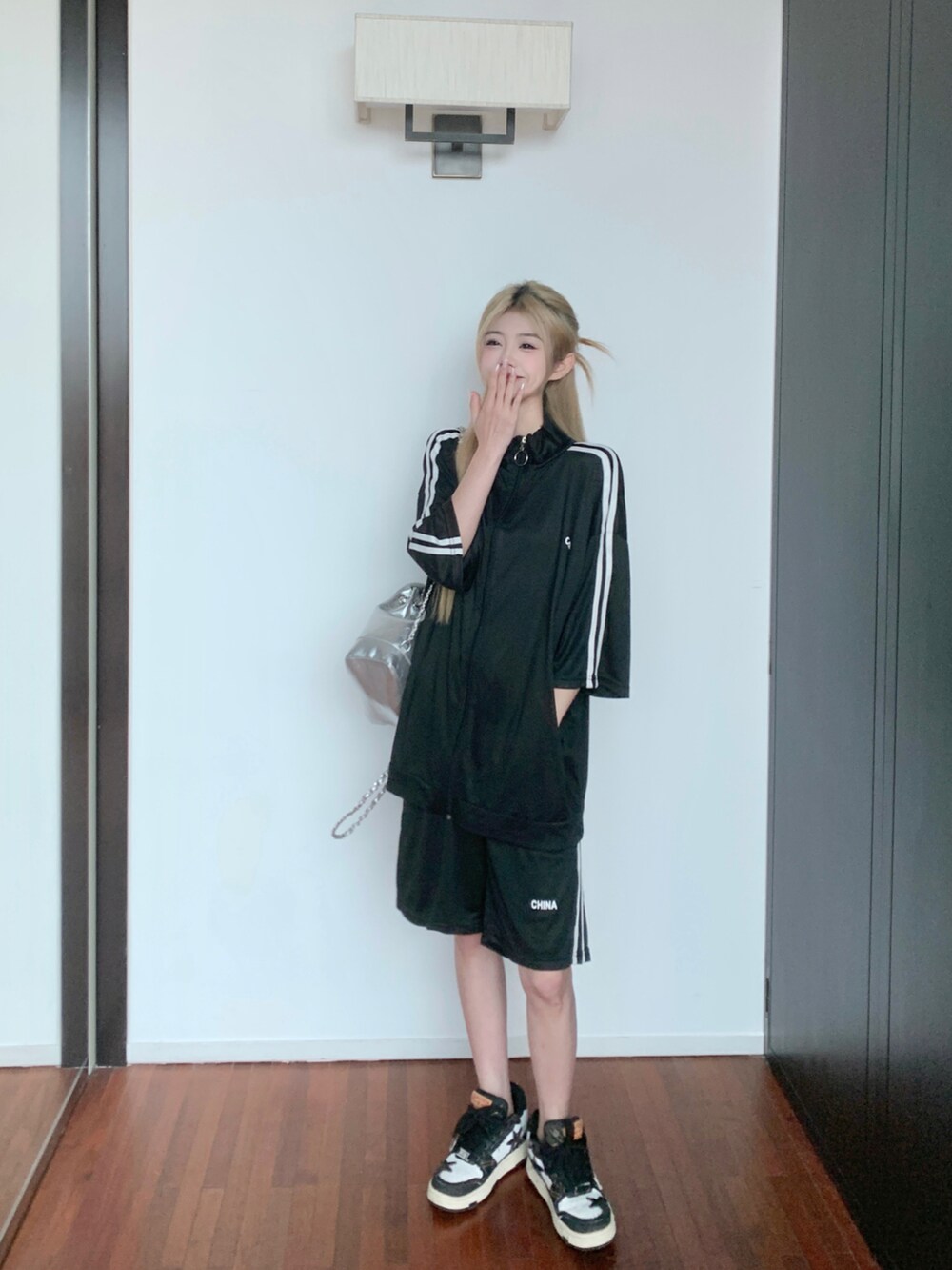 ブラック系のジャージを着用したレディースの夏コーディネートの4枚目の写真