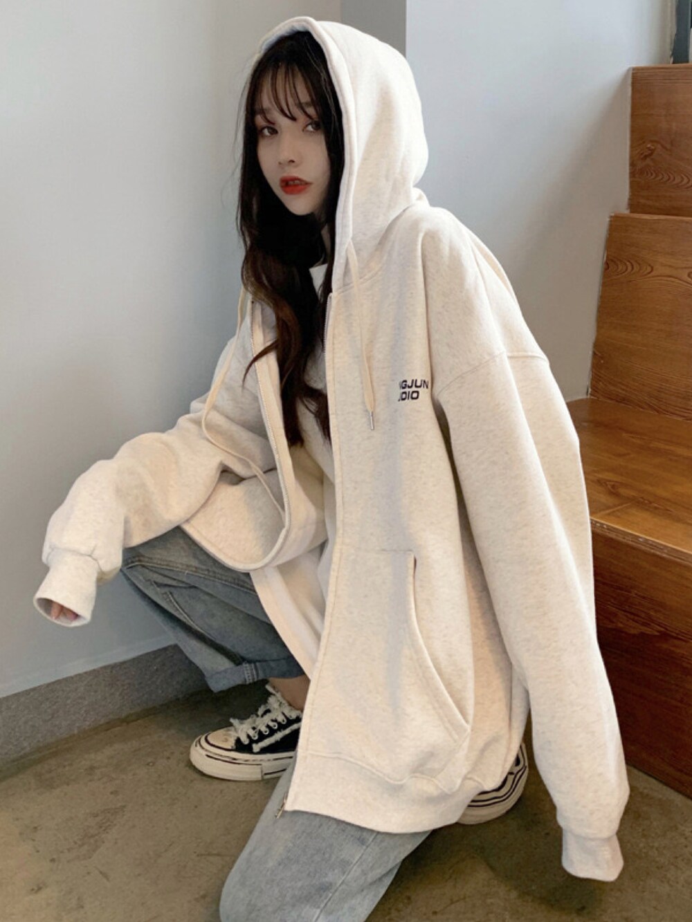 ベージュ系のパーカーを着用したレディースの冬コーディネートの2枚目の写真