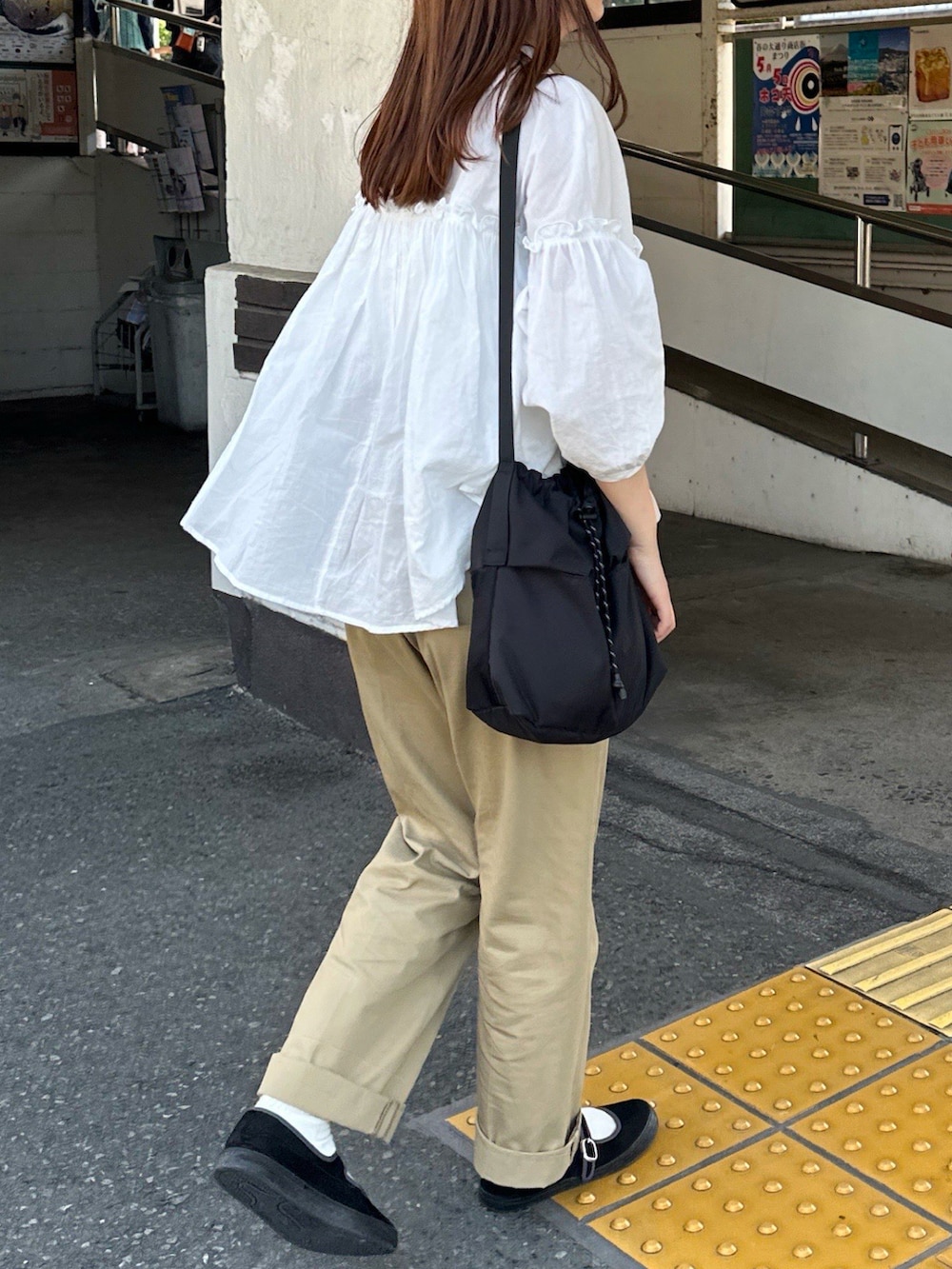 ブラック系のショルダーバッグを着用したレディースの夏コーディネートの2枚目の写真