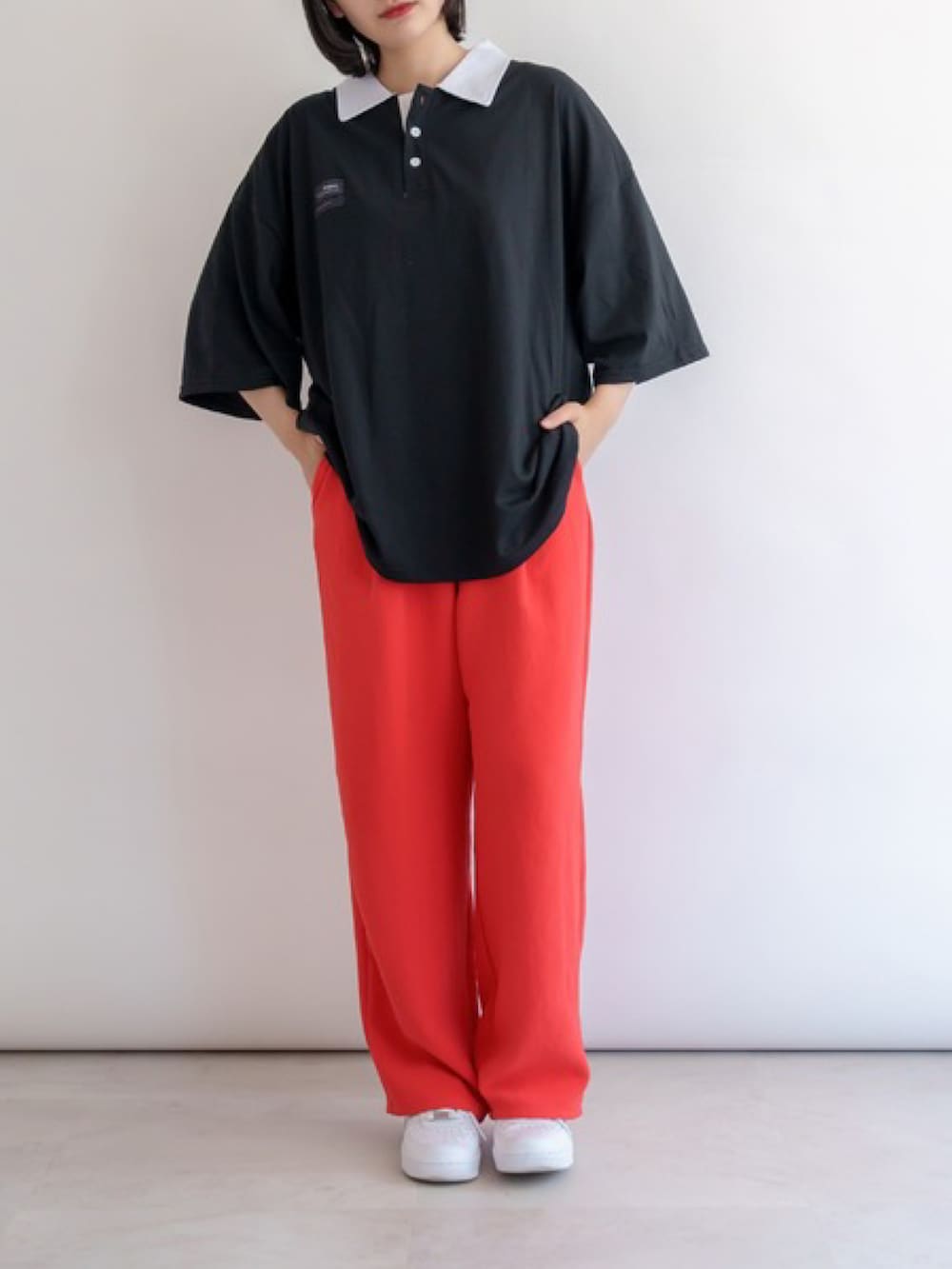 ブラック系のポロシャツを着用したレディースの夏コーディネートの5枚目の写真