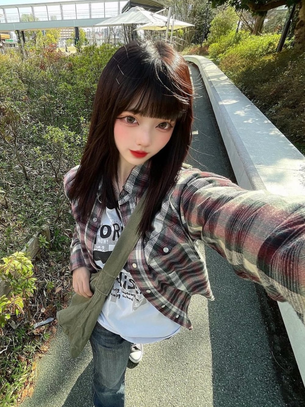 グリーン系のショルダーバッグを着用したレディースの春コーディネートの2枚目の写真