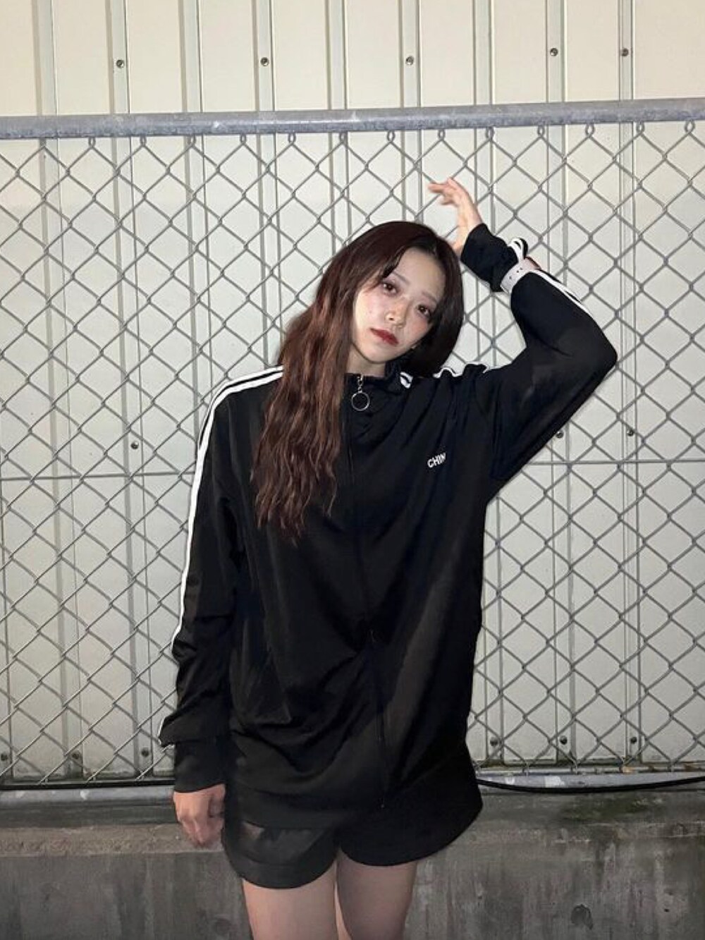 ブラック系のジャージを着用したレディースの春コーディネートの3枚目の写真